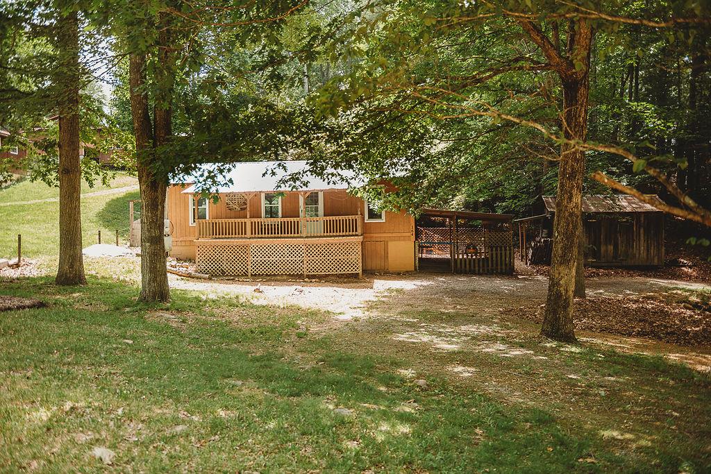 Escape to the mountains without spending a fortune! Nestled on a peaceful and private -acre wooded lot, this charming cabin offers the perfect getaway for outdoor enthusiasts, weekend adventurers, or anyone seeking a simpler pace of life. Enjoy the serenity of nature from the inviting front and rear covered porches, while modern conveniences like fiber optic internet make it easy to stay connected when needed. Designed for low-maintenance living, the cabin features a durable metal roof, new vinyl tilt thermal windows, and a cozy wood pellet stove for year-round comfort. Outside, you'll find a fenced patio area for pets, a garden space, and an outdoor storage shed for all your recreational gear. Ideally located with easy access to the surrounding natural attractions, including hiking, biking, and fishing opportunities in the nearby National Forest and Hale's Lake. You'll also be just a short drive from Rural Retreat Lake, Mount Rogers Recreation Area, and the Virginia Highlands Horse Trail system. Water and sewer are provided by a freshwater cistern and holding tank system, making this an affordable mountain retreat with everything you need to unwind and enjoy the outdoors. Whether you're looking for a weekend escape, vacation rental opportunity, or your own private hideaway, this cozy cabin is ready to welcome you home.