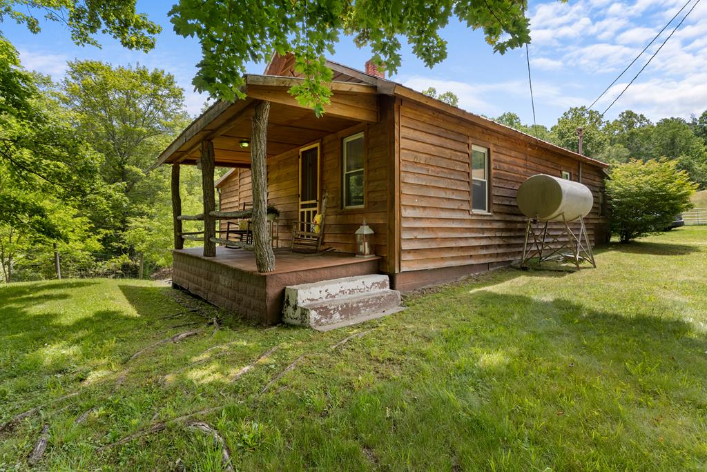 AHHHHH... Listen to the birds sing from the front porch and experience the peaceful beauty of Elk Creek Valley. Nestled on 1.788 picturesque acres with a gentle stream, mature trees, and pastoral views, this lovingly restored 1940 cottage offers the perfect blend of country charm and modern comfort. The 2-bedroom, 1-bath home has been carefully maintained while preserving its character and warmth, creating an inviting retreat where family memories are made. The property features beautiful wood floors, a spacious porch, detached two-car garage, outbuilding, partial basement, well and septic, and plenty of room for gardening, hobby farming, or a small homestead. Neighboring sheep grazing nearby add to the tranquil country setting. Whether you're looking for a full-time residence, weekend getaway, vacation rental, artist's retreat, or Airbnb opportunity, this special property offers endless possibilities. Spend your mornings with coffee on the porch, afternoons exploring the countryside, and evenings relaxing to the sounds of nature. Conveniently located in scenic Grayson County, this charming cottage is ready for its next chapter. Come experience the peace, privacy, and simple pleasures of country living.