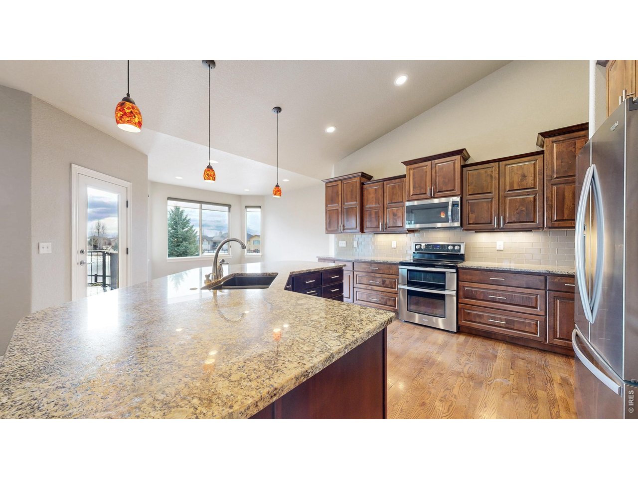 Enjoy the best of both worlds-watch golfers tee off across the street on Hole #4 or unwind on your expansive back deck overlooking a tranquil pond. Nestled in the prestigious Highland Meadows Golf Course community and located within the highly acclaimed Poudre School District, this thoughtfully designed home offers 5 bedrooms, 4 bathrooms, a main-floor office, and a 3-car garage. Fresh, plush carpet adds warmth throughout, while generous room sizes and abundant walk-in closets provide comfort and functionality. Designed with entertaining in mind, the gourmet kitchen is the heart of the home, featuring an impressive oversized island with seating for six, soft-close cabinetry, pull-out storage, and an open layout that flows into the dining and living areas. Morning sunlight pours through the windows, filling these spaces with natural light. A convenient mudroom just inside the garage helps keep everything organized.The spacious garden-level basement with two bedrooms connected by a Jack-and-Jill bath featuring separate vanities and a private shower/water closet. An additional bedroom or office shares a cozy double-sided fireplace with the family room. You'll also find a stylish wet bar with an island, plenty of room for a home gym or recreation area, plus a flip-up workspace and utility sink in the unfinished storage area. Outside, the extended deck offers both covered and open-air spaces, while the lower patio invites you to relax beside the serene pond. The beautifully xeriscaped backyard features pet-friendly turf, a pre-wired location for a future hot tub, and the option to fence the side yard for even more grassy play space. A greenbelt bordering one side of the property enhances the open feel. Outstanding neighborhood amenities, include a swimming pool, outdoor tennis courts, future pickleball courts, and a stunning clubhouse with a full fitness center, oversized hot tub, dry sauna, kitchen, fire pit, and grilling area. Best of all-there are no HOA fees!