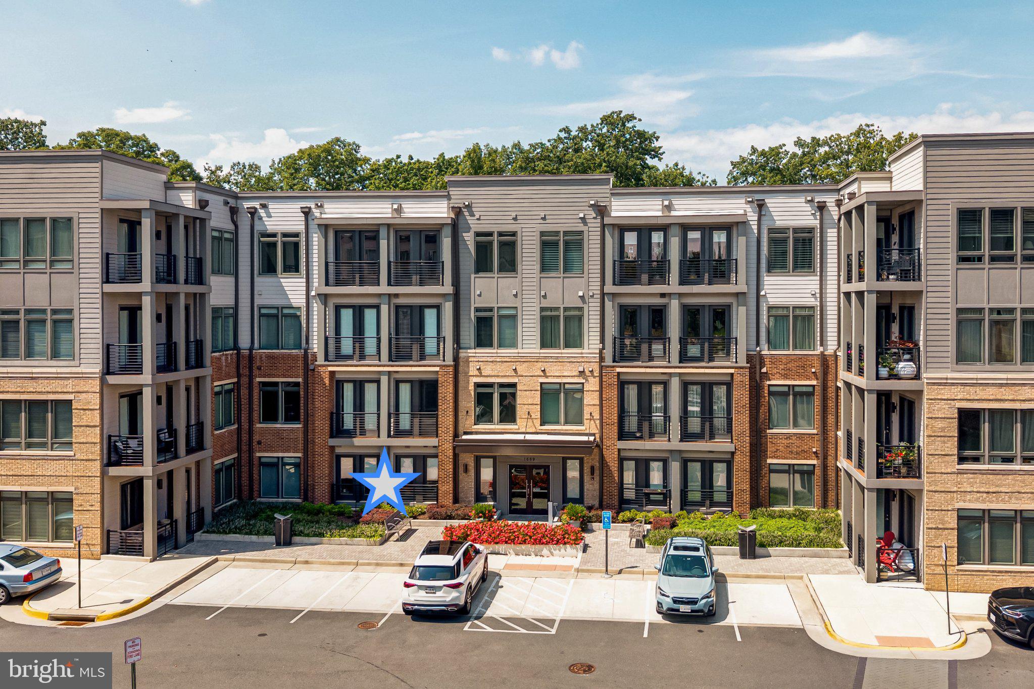 Welcome to the Flats at Tall Oaks, a newer Stanley Martin community built in 2022 and ideally located in the heart of Reston. This beautifully appointed ground-floor condo at 1669 Bandit Loop #105A offers a bright, welcoming setting with an open-concept floor plan designed for comfortable everyday living and easy entertaining.Natural light fills the main living spaces, where luxury plank flooring flows from the kitchen into the dining and living areas. At the heart of the home, the spacious kitchen features an oversized quartz island, plentiful cabinetry, stainless steel appliances, and a custom tile backsplash—creating a warm and functional gathering space for everything from morning coffee to evenings with friends.The primary suite offers a peaceful retreat with a private en-suite bath featuring a large walk-in shower, double-sink vanity, upgraded tile, and an extra-large walk-in closet conveniently positioned just off the bathroom. The secondary bedroom, also spacious, offers a  second full bath with upgraded tile, generous storage, and a tub/shower combination.One of the home's greatest advantages is its ground-floor location, providing easy access to the outdoors and a particularly convenient lifestyle for those with pets or anyone seeking minimal stairs. The assigned secure underground parking space for this condo home is in the attached garage which also includes dedicated bicycle storage.Beyond your front door, the best of Reston is close at hand. The community pool is located just across from the building, while the Wiehle-Reston East Metro Station is only moments away. For those who enjoy being outside, Reston's extensive network of trails provides countless opportunities to walk, run, and explore, with the W&OD Trail just blocks away for longer rides and scenic outings.As a member of Reston Association, residents also enjoy access to swimming pools, tennis and pickleball courts, walking trails, community events, and an abundance of green spaces woven throughout the community. Shopping, dining, commuter routes, and everyday conveniences are all nearby, making it easy to enjoy both the energy of Reston and the tranquility of its natural surroundings.With water, sewer, trash, and common-area maintenance included in the monthly condo fee, this is an inviting opportunity to enjoy newer construction, outdoor access, and a wonderfully connected Reston lifestyle—all with the ease of low-maintenance living.