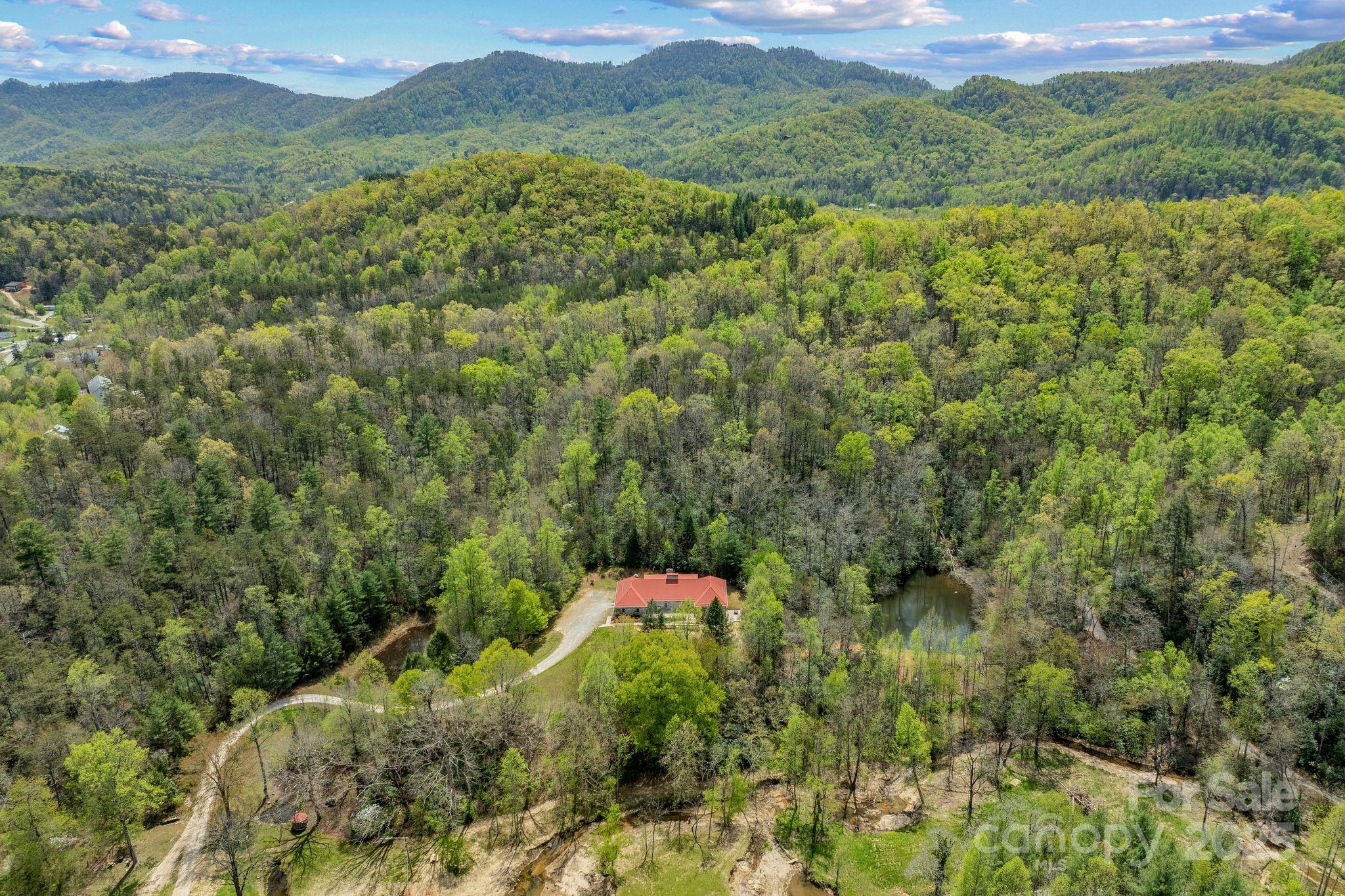 Welcome to your outdoor paradise on 36 unrestricted acres! Little Crooked Creek, spanning nearly 2000 feet through the property, flows year round with your own swimming area and waterfalls. Clear some trees to open up sweeping long range mountain views up on the hiking trail. Two spring fed ponds are a short walk from your French Styled, all brick, 7,550 square foot, 3 level home with 7 Bedrooms (3 full primary Bdr's, 5 Bdr septic permit), 5.5 bathrooms, 2 updated kitchens, 4 woodburning fireplaces and 3 car garage. Additional recent updates include brand new flooring, lighting, paint, landscaping and a 1000 ft farmhouse fence where horses and farm animals can roam inside. Thousands of feet of gentle slopes and level ground throughout the property make it ideal for RV's, new homes, glamping, B&B, farming, trails, corporate or recovery retreats (home has separate private entrances, great for retreat property!). Minutes to Old Fort, 15 min to Black Mtn. and 25 min to Asheville.
