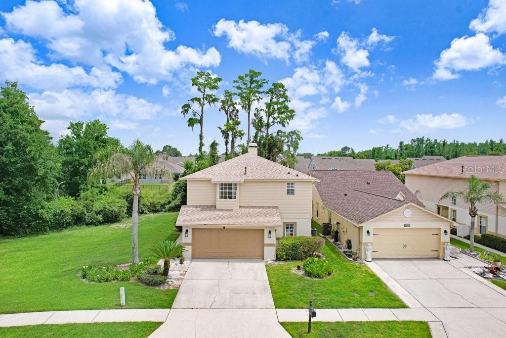 STUNNING TWO-STORY GREAT ROOM! FLOOR-TO-CEILING STONE FIREPLACE! PRIVATE WOODED BACKDROP!Welcome to this beautifully maintained 3-bedroom, 2.5-bath home in the desirable Fairways at Quail Hollow community of Wesley Chapel. From the moment you enter, you'll be impressed by soaring ceilings, abundant natural light, and a dramatic two-story great room anchored by a stunning floor-to-ceiling stone fireplace that serves as the centerpiece of the home.Enjoy peace of mind with major updates already completed, including a ROOF 2023, A/C COMPRESSOR 2024, and WATER SOFTENER 2025. Premium ceiling fans throughout the home provide both comfort and style, while updated luxury vinyl flooring enhances the home's modern appeal.Designed for both everyday living and entertaining, the open-concept floor plan features a spacious formal dining area and a beautifully updated kitchen complete with a large center island, abundant cabinetry, generous counter space, and room for gathering with family and friends. The kitchen flows seamlessly into the main living area, creating an ideal space for entertaining.The oversized primary suite offers a true retreat with vaulted ceilings, dual vanities, a garden tub, separate shower, and ample storage. Additional bedrooms provide flexibility for family, guests, or a home office.Step outside to the screened lanai and enjoy a private backyard setting with mature trees creating a peaceful wooded backdrop rarely found at this price point. Additional features include an interior laundry room and a two-car garage.Conveniently located near The Grove, Tampa Premium Outlets, Wiregrass Mall, dining, entertainment, medical facilities, and major commuter routes including I-75, this home offers the perfect combination of space, character, privacy, and convenience.Schedule your private showing today!