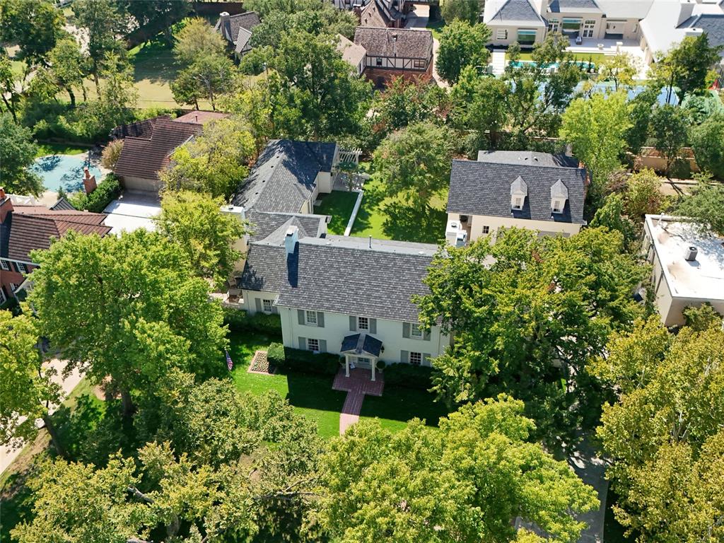 Set along coveted Avondale Drive, in the heart of Nichols Hills, this extraordinary 1932 white Colonial is a love letter to timeless architecture, thoughtful reinvention, and the art of living beautifully. Rooted in classic American and British design, the residence was reimagined, preserving its historic soul while introducing an unexpected collection of richly layered, deeply personal spaces.Original hardwood floors, gracious proportions, and multiple living areas create a sense of warmth and permanence. A timeless white kitchen, appointed with calcutta marble countertops, anchors the home, while the more intimate spaces reveal its true personality. A jewel-box bar wrapped in Fortuny Fabric walls and antique mirrors feels borrowed from another era. A striking powder bath, dressed in onyx and terracotta, is just one of the many delightful departures from tradition. Every turn offers something worth discovering.The main-level primary suite is a private world of its own. Vaulted ceilings, a secluded lounge, and a private patio create an extraordinary retreat, while separate his-and-hers baths and dressing rooms offer two distinct expressions of luxury. Hers is decidedly romantic, with French-inspired details, pink onyx countertops, and a dedicated cedar closet. His is tailored and masculine, with a distinctly Ralph Lauren sensibility and a rather wonderful secret: a concealed cocktail lounge, complete with its own wet bar.Upstairs, three beautifully appointed en suite bedrooms and a generous bonus room offer comfort and privacy for family and guests.Beyond the interiors, the grounds feel almost enchanted. Expansive patios and Mature trees create an intimate, beautifully secluded setting. Completing the estate is a four-car garage with a fully functioning apartment above, offering an exceptional space for guests. A home of remarkable character, quiet grandeur, and a little bit of magic. The kind of property that could never be replicated.