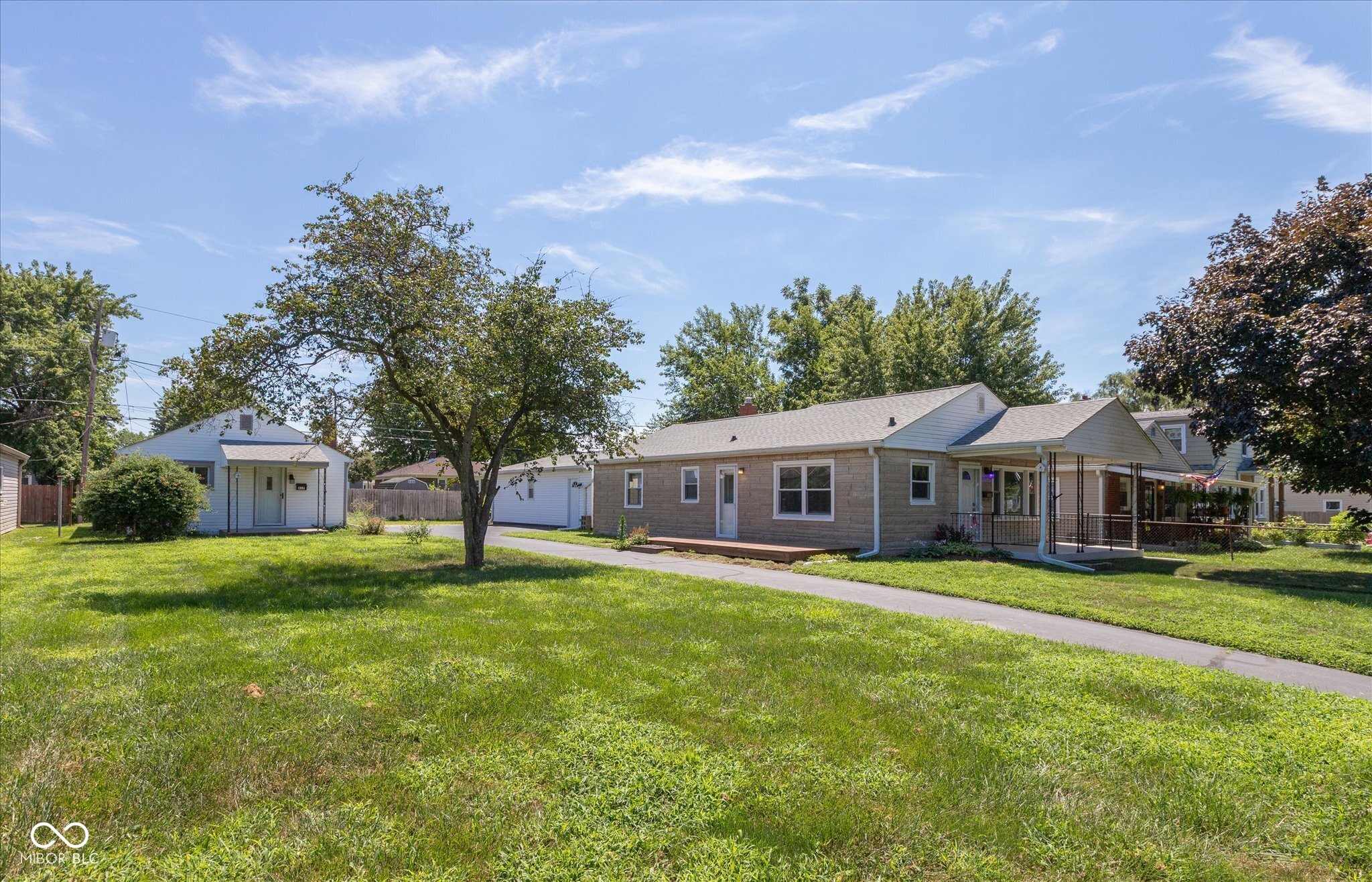This charming limestone bungalow boasts a warm and inviting appeal, highlighted by the stunning original hardwood floors that flow throughout the living spaces. The heart of the home is the kitchen, featuring custom handmade cabinets that offer both beauty and functionality with a unique touch of craftsmanship.  The layout includes three bedrooms, providing ample space for family or guests. A full basement enhances the home's versatility, housing a cozy family room with fireplace perfect for gatherings and relaxation. Outside, you'll find an oversized two-car heated detached garage with window air conditioner, offering additional storage and workshop potential. An uncommon feature of this home is the driveway extending from the street to the alley, providing easy access and convenience.   Complementing the main residence is a one-bedroom accessory dwelling, ideal for in-laws, guests, rental income, or a private office space. This property seamlessly blends comfort, character, and practicality, making it a perfect home.