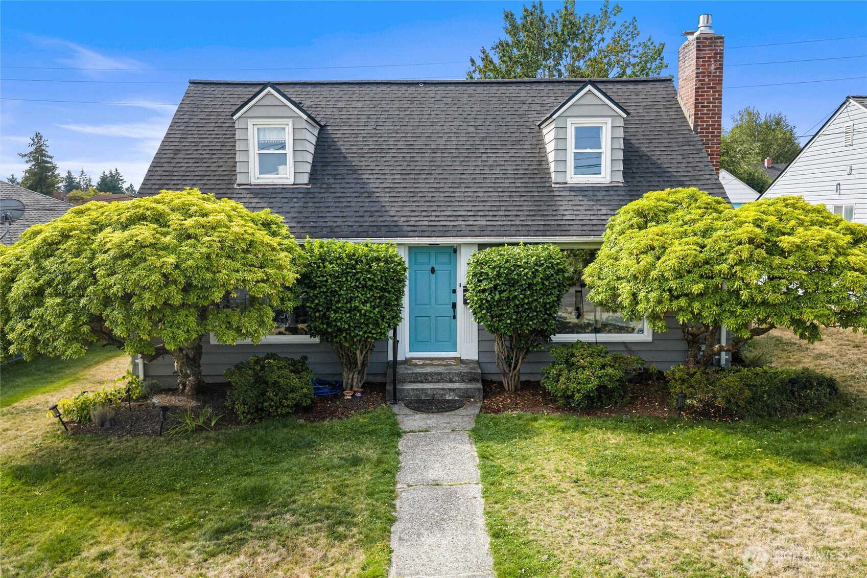 Beautifully restored Cape Cod in desirable North Tacoma, offering a rare blend of timeless character, thoughtful modern upgrades, and a spacious, fully fenced backyard designed for entertaining. Rich hardwood floors, updated fixtures, and a stunning custom tiled fireplace create warm, inviting spaces throughout. Natural light pours into the home through a large picture window in the living room and an equally expansive window in the kitchen, creating bright, light-filled living spaces with beautiful views of the front and backyard. The open-concept design offers effortless flow for everyday living, gathering with friends, and hosting, while the beautifully updated kitchen features generous counter space, abundant storage, updated countertops, and newer appliances. The remodeled lower-level bathroom and refreshed main floor bath add style and function, while the expanded deck and patio provide the perfect setting for summer barbecues, morning coffee, or relaxing evenings outdoors. Recent improvements include a heat pump with mini-split A/C, updated electrical panel with new breakers, grounding rod, newer south-facing roof, Hardie siding on the rear dormer, upstairs carpet, and western-side fencing. Just four blocks from Kandle Park, eight blocks from Metropolitan Market, and moments from Proctor District’s beloved local restaurants, and boutique shopping. This exceptional home offers the perfect blend of classic North Tacoma charm, modern comfort & an incredible life.