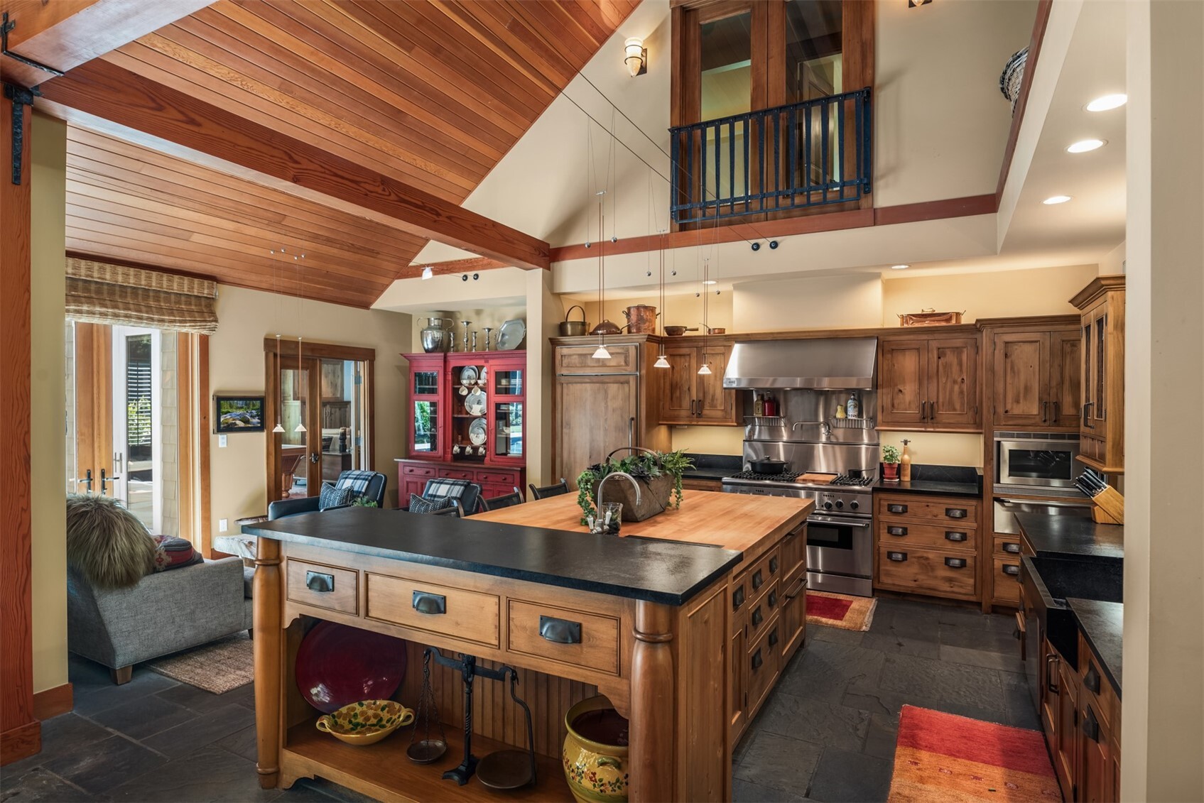 Kitchen with wood island, stainless range, and vaulted wood ceiling