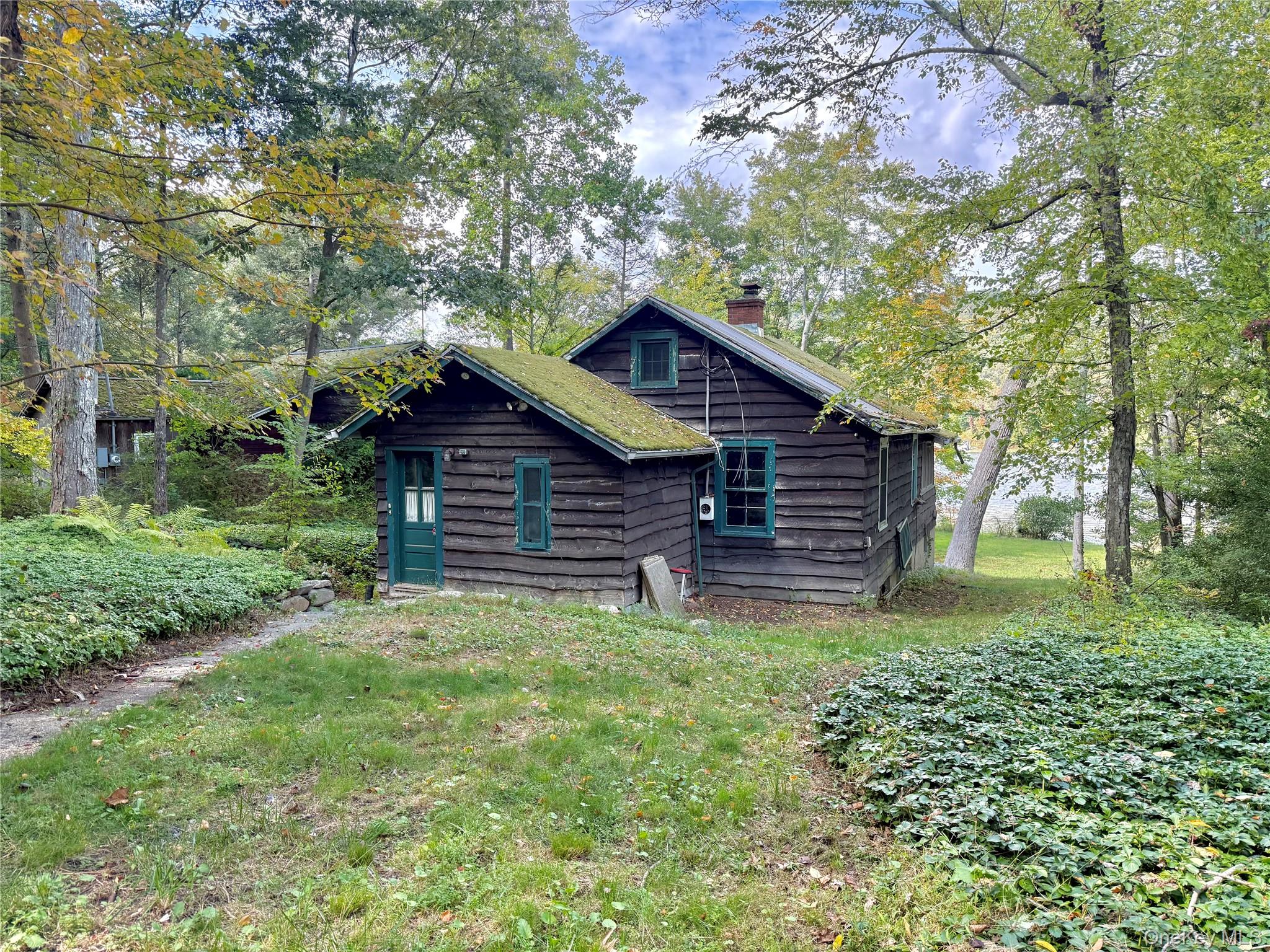 Opportunity for direct waterfront!!! Come see this cabin that is situated directly on the shoreline of Lake Waccabuc in quiet lake community. The structure itself is built primarily of beautiful wood siding and features a wood burning stove with a stone and mortar foundation. Large, multi-pane window line facing the water makes for great entertaining or relaxing providing an unobstructed view of the lake. The interior consists of an open-plan living space with exposed wooden beams. The flooring is made with real 3 1/3 x 3/4 hardwood. A compact kitchen is ready for you to put your own personal touches on it. The property includes a gentle, grassy slope that leads down to the water's edge. Mature oak and maple trees offer partial shade along the sides of the clearing, while the view of the lake remains open. The location is in an area characterized by its wooded landscapes and proximity to several reservoirs creates a great environment for a weekend getaways to include hiking boating and other outdoor activities all within a stones throw from NYC. Schedule your tour today as this one will not last long.