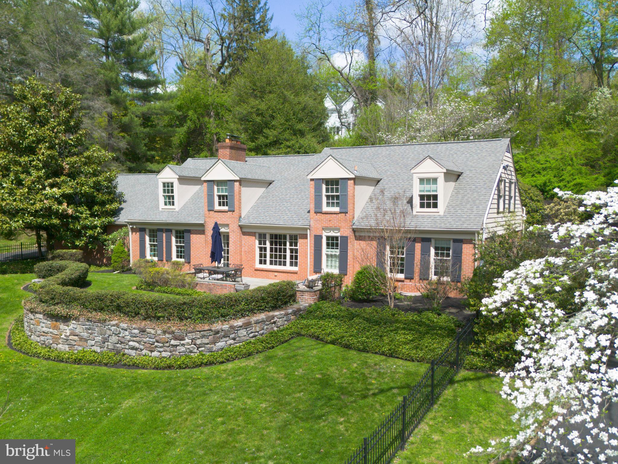 A rare Lower Merion lakefront offering with expansive first-floor living, 415 Dove Lake Road pairs unobstructed water views and privacy with a highly functional, family-oriented layout.Set directly across from Dove Lake in Gladwyne, the home is defined by its setting—open water views, mature trees, and a quiet, tucked-away feel just minutes from Center City. The landscape and light shift throughout the day, creating a setting that is both visually striking and uncommon for the area.Thoughtfully expanded and rebuilt at the main level, the home offers over 3,300 square feet with a predominantly first-floor layout designed for everyday living and entertaining. The kitchen, dining, and living spaces flow together, centered around a fireside living room that functions as the home’s primary gathering space. The kitchen is well-equipped for both daily use and hosting, with an induction cooktop, double ovens and two dishwashers. Glass doors open to a large patio and level, fenced yard, extending the living space outdoors. The setting supports a range of uses—from entertaining to play—while maintaining a sense of privacy. A circular drive wraps the property, providing ample parking and access to the attached garage, with an 18th-century springhouse offering additional storage or garden use.The bedroom layout is flexible and well-suited to a variety of needs featuring a first floor primary suite, with many options for expansion. A separate upstairs suite accessed by a dedicated staircase provides ideal space for guests, in-laws, or an au pair. Additional bedrooms across the main and upper levels offer versatility for family, office, or guest use.Recent improvements include a new driveway (2026), updated patio (2019), refreshed landscaping, and mechanical and electrical upgrades that support long-term livability.The result is a home that combines a rare natural setting with a practical, livable floor plan—offering both retreat-like surroundings and everyday functionality in one of Lower Merion’s most desirable locations.