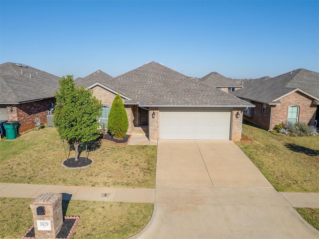 One-owner former model home in The Grove! This 3-bedroom, 2-bath home offers an open layout with a formal entry, wood-look tile throughout the main living areas, upgraded light fixtures, and large windows throughout. The living room features a cozy gas fireplace, and the kitchen has granite countertops, stainless steel appliances, a gas stove, and plenty of cabinet space. The large eat-in dining area features beautiful wood detail beneath the window. The primary suite includes a nook with matching wood detail, TWO walk-in closets, double sinks, a garden soaking tub, and a tiled walk-in shower. Both secondary bedrooms also have WALK-IN closets, giving this home tons of great storage. Additional features include a tankless water heater, built-in security system, in-ground storm shelter, and a large two-car garage. Outside, you'll find established landscaping and mature trees in front, plus a large, flat, fully fenced backyard. The Grove has amazing amenities including Grove Valley Elementary School within the neighborhood, two pools, two fitness centers, a basketball court, stocked ponds, playgrounds, and miles of paved walking trails. Shopping and dining are located right within the addition, and the home is in Deer Creek Schools with quick access to the Kilpatrick Turnpike and major highways!