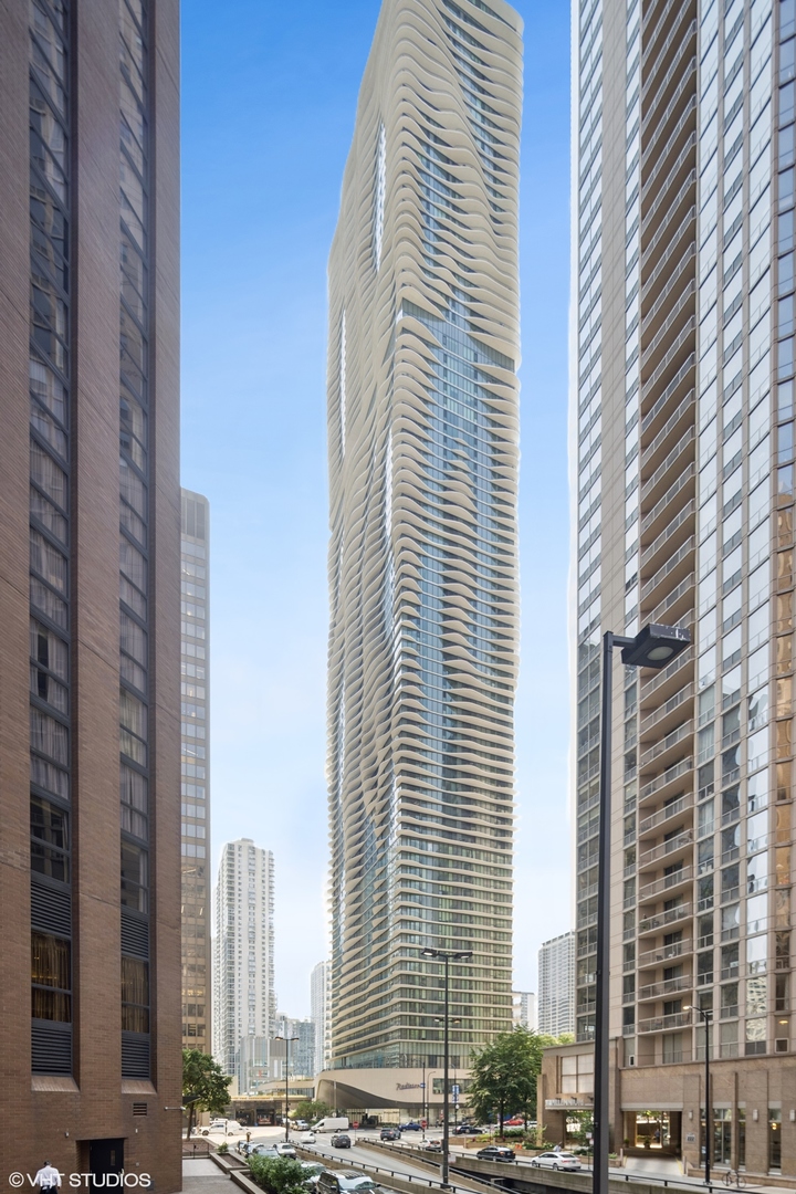 Experience luxury living in this custom designed modern corner condo in the award-winning Aqua Building. Floor to ceiling windows offer stunning panoramic views of the lake, Grant Park and the western skyline.  Enjoy unique outdoor living on the 75 foot terrace.  Spacious living room and dining areas feature ash hardwood floors and carefully selected designer lighting.  The kitchen boasts modern Snaidero cabinets, quartz countertops and backsplash along with Wolf and Miele stainless appliances. A stunning additional living space with western skyline views can be used as a den, office or a third bedroom and has been carefully designed with a media built-in unit. Escape into the primary bedroom suite with custom walk-in closet and tranquil spa bath with yet more stunning views.  Additional design touches include custom millwork, oversized doors and window treatments.  The Aqua Building was thoughtfully created and offers some of the best amenities in the city including indoor/outdoor pools, basketball court, fitness center along with a private club suite for owners. This is a unique must-see corner unit.