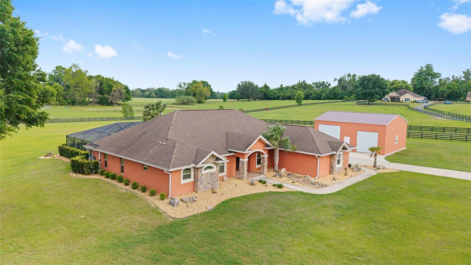 Just 15 minutes from downtown Ocala, this beautiful home sits on 5.42 acres of land! Surrounded by wide open skies located in Manor Hill Estates, this well-maintained property offers a comfortable and functional layout, perfect for everyday living. Step inside to find wooden floors, sliding barn doors, an open concept, and an inviting interior. The kitchen offers ample cabinetry and workspace, making home-cooked meals a breeze. Spacious bedrooms provide flexibility for guests, a home office, or hobby space. Step outside and you'll enjoy a solar heated pool that's completely caged in alongside a covered patio. Adjacent to this, there's a detached completed garage with oversized doors offering plenty of room for storage! This property provides peace and comfort in a stunning natural setting.