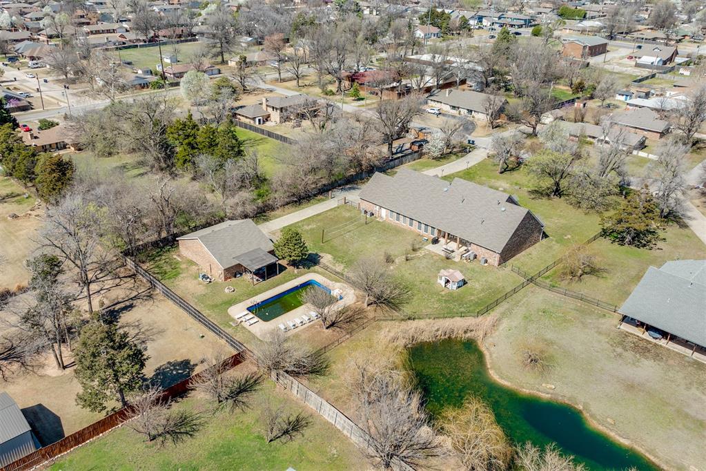 Welcome to the ultimate entertainer’s retreat—set on a beautiful, tree-studded 1+ acre lot in the coveted Bush Hills neighborhood of Oklahoma City. Offering rare privacy, generous space, and resort-style outdoor living, this property is designed for year-round enjoyment. The backyard is a true oasis, featuring a large pool, grass volleyball court, expansive lawn, and a spacious covered patio ideal for quiet mornings or unforgettable evenings with family and friends. Inside, the home is equally impressive. The bright, airy living room is framed by dramatic picture windows showcasing sweeping backyard views. The oversized kitchen offers extensive cabinetry, a large center island, abundant prep space, and a casual dining area overlooking the outdoor living space. A full walk-in butler’s pantry adds exceptional storage. The formal dining room provides an elegant setting for holidays and special occasions. The private primary suite is its own retreat with direct backyard access. The ensuite bath includes dual vanities, a soaking tub, walk-in shower, and two oversized walk-in closets. The main level also features four additional bedrooms and two and a half bathrooms, offering excellent flexibility for family, guests, or office use. Upstairs, a large bonus room functions as the ultimate hangout—perfect for movies, game nights, or extended guest stays. Additional highlights include a three-car garage with above-ground storm shelter and major recent upgrades: new roof (2023), full HVAC replacement (2023), and energy-efficient foam insulation in exterior walls and the living room ceiling. Car lovers and hobbyists will appreciate the 1,300 sq ft detached garage/workshop, offering outstanding space for projects and storage. As a rare added perk, the home may be sold furnished for a turnkey experience. Just in time for spring and summer—this one is made for making memories. Let the fun begin.