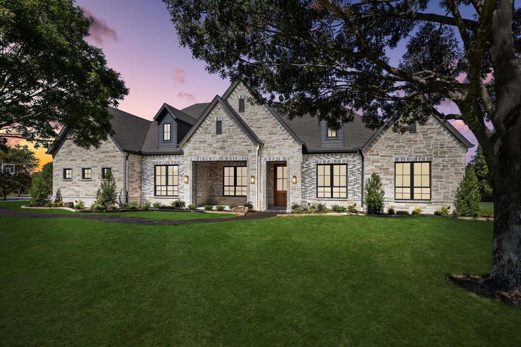 Completed in 2025 by Tim Jackson Custom Homes, 871 Beechwood Lane is a newly rebuilt Fairview estate that blends timeless design with modern efficiency in Lovejoy ISD. Reconstructed from the original engineer-inspected foundation after a lightning strike, this six-bedroom, six-and-a-half-bath home features all-new systems, finishes, and craftsmanship of the highest caliber. The open-concept layout is filled with natural light from walls of Andersen windows, highlighted by exposed wood ceiling beams and a stone fireplace with reclaimed wood mantel. Solid white oak flooring flows throughout, complemented by black window frames, smooth Level 5 finished walls, and custom soft-close built-ins. A custom Mahogany front door sets the tone for the home’s warm elegance.
The kitchen boasts custom full-overlay, soft-close cabinetry, a large quartzite island, JennAir appliances, and a well-equipped butler’s pantry with secondary refrigerator, dishwasher, microwave, and sink. The primary suite offers a tray ceiling, large windows, and a spa-style bath with soaking tub, oversized frameless shower, and dual quartzite vanities. Three secondary bedrooms include private en suites with walk-in showers, while two additional bedrooms share a connected bath in a separate guest space.
Structural highlights include 16-inch framing, solid-core doors, full-encapsulation foam, and a 23 SEER HVAC system. Additional features include a spacious laundry room with sink and built-ins, a dedicated Costco closet, and an oversized three-car garage with epoxy floors and stained Cedar garage doors. Outdoor living shines with a covered patio featuring a tongue-and-groove wood ceiling and dual fans overlooking a resurfaced pool and spa with waterfall feature, plus a stone cabana with fireplace, bar seating, and DCS grill. The property also offers a sports court with basketball and regulation pickleball lines, all framed by mature trees and fresh landscaping.