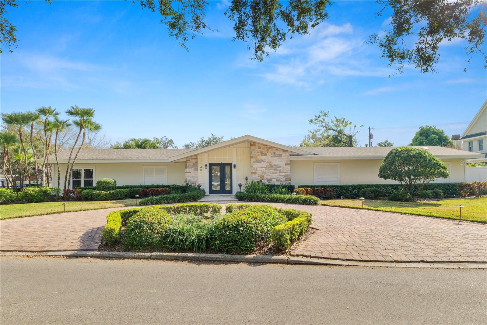 Welcome to this fantastic mid-century modern POOL home located in a prime location within walking distance to Lake Hollingsworth, with easy access to shopping, dining, and schools. This split plan home features 4 bedrooms and 4.5 bathrooms and a dedicated gym! Arriving at the home, you’ll appreciate the separate circular driveway, beautifully manicured lawn, and side entry oversized garage with extra storage closet. Entering the home, you’ll find crown molding and hardwood floors in the large foyer with plenty of closet space. The spacious living room features a wood burning fireplace and leads into your stunning kitchen. The kitchen has shaker style cabinets, granite countertops, stainless steel appliances, and stained barn doors leading into the spacious pantry. There is also a breakfast bar area, perfect for those quick meals. Off of the kitchen, you’ll find a large formal dining room, with plenty of space for entertaining, as well as an additional sitting area with a pass thru to the kitchen. There is a wall of french doors that lets in plenty of natural light that leads to your stunning outdoor patio and pool area. The primary bedroom wing is spacious and bright and offers access to your personal gym, through barn doors. The en-suite bathroom has a large dual sink vanity with storage, a stand up shower, and large freestanding soaking tub. Additionally there is a huge walk in closet as well as a secondary closet! The remaining bedrooms are located on the opposite side of the home, each with their own walk in closet. There is also a secondary primary suite/guest suite at the back of the home with its own bathroom, large closet and wetbar and its own entrance. This home would be perfect for generational housing or even earn some income by renting out the secondary primary suite. Outside you’ll find your very own paradise with a large covered patio with access to the half bathroom and storage, an oversized 16x32 inground saltwater swimming pool all surrounded by beautiful pavers and a lovely landscaped yard. This home has so much to offer! The home was professionally remodeled in 2017 and has all the modern touches from light fixtures to finishes that you can enjoy without the upkeep of an older home!  Schedule your private showing today!
