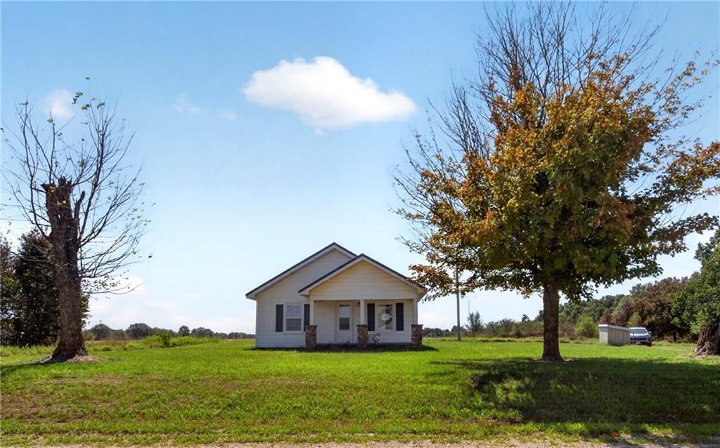 What if home meant a little more room to breathe? Leave the close quarters of town behind & come home to wide-open views, fresh country air, all on 1 acre of your own land only 10 minutes from town. Only 2 miles on gravel road, this charmingly renovated, 2 bedroom, 1 bath, bungalow offers peaceful country living with expansive farmland views. Picture your mornings with a cup of coffee on the covered front porch, watching the neighboring horses across the road as the countryside wakes up. In the evenings, move to the covered back porch, breathe in the fresh evening air & watch for deer & other wildlife while the sun settles over the open field. With beautiful sunrise and sunset views, this is a home that invites you to slow down & enjoy where you live. Inside, approximately 800 sq. ft. of one-level living has been thoughtfully updated, with most of the important improvements already completed. Updates include new electric service & a new metal roof in 2025, new thermal windows throughout & additional insulation added, for energy efficiency.  The seller has gone through the home from top to bottom with the goal of having it move in ready for its next owner. The home is all electric and served by its own private well, helping keep country living simple with no monthly water or gas bill. Recently the well water was tested, & the septic system was checked & pumped & both are fit as a fiddle! Outside, the land gives you room to create the country lifestyle you’ve been imagining. Plant a large vegetable garden, add fruit trees, enjoy outdoor hobbies or simply appreciate having elbow room to grow. When you’re ready for a day on the water, Stockton Lake a short 15 minutes away. Whether you’re looking for your first home, simplifying to one-level living, dreaming of a small homestead with chickens & livestock, searching for a peaceful country retreat or simply ready to trade traffic lights for open skies & panoramic views, this may be exactly what you’ve been waiting for!