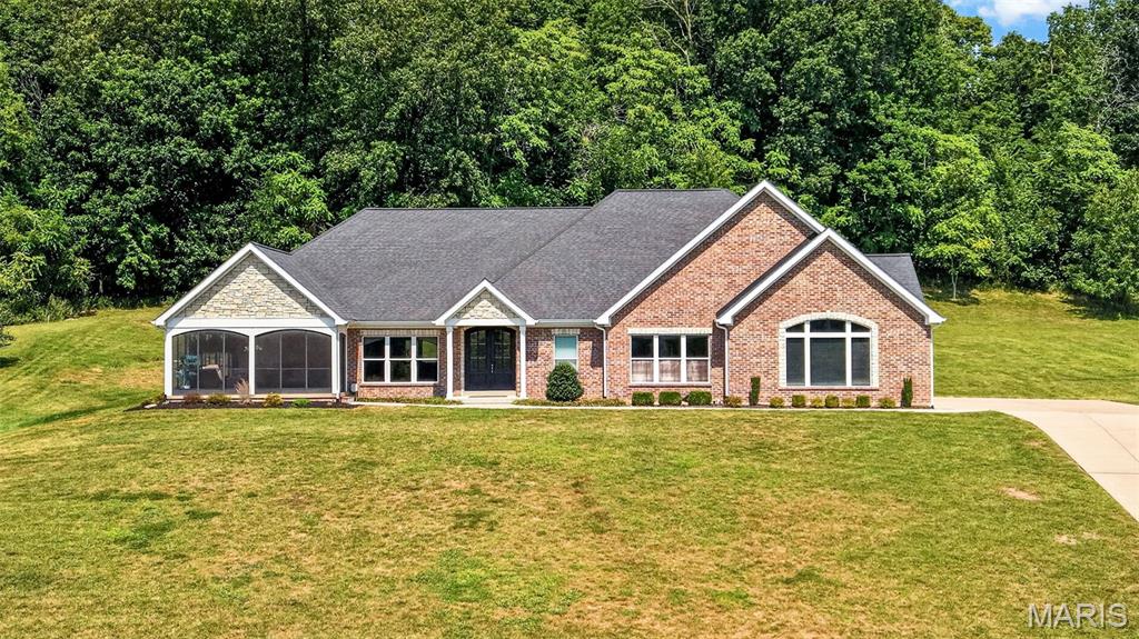 Welcome to paradise! This spectacular home awaits you in the prestigious, gated Augusta Shores Subdivision. This stunning 2,660 above grade square-foot ranch style home with over 3800 total living space offers unobstructed, breathtaking views of Berg Pond, Klondike Park, and the entrance to the iconic Katy Trail. Soak in those gorgeous views year-round from the dining room, primary bedroom, living room, kitchen, and the beautiful, oversized screened porch. Space, style, and sophistication come together in a thoughtfully designed open-floor plan, making this home as functional as it is breathtaking. No detail was overlooked when it was built nine years ago, making it one of the newer homes built in the subdivision.So many features! The kitchen is a showstopper, featuring custom-made, Amish-crafted cherry wood cabinets, quartz countertops, stainless steel appliances, and a walk-in pantry. Arched doors and doorways and rich red oak hardwood floors flow seamlessly from room to room. The primary suite bath is your personal retreat, featuring lighted Kohler mirrors, a walk-in shower with dual shower heads — including a luxurious rain shower and the primary bedroom has a walk-in closet, along with an additional closet and remote-controlled shades. A jetted tub highlights the secondary bath, while a walk-in butler’s pantry with extensive cherry wood cabinetry, a wet bar, and an ice machine makes entertaining an absolute dream. Additional highlights include a floor-to-ceiling remote controlled fireplace, tinted windows, tray ceilings, and pocket doors.Head downstairs on an extra wide oak staircase and prepare to be wowed! The lower level features a large recreation room with a simply phenomenal custom-built bar and expansive custom-made bookshelves. Also on the lower level: a full bath, an additional bedroom, a dedicated fitness room, and a large unfinished basement area for all of your storage needs.Outside, the property backs to trees and includes a full irrigation system, exterior lighting, three Ring cameras, and an invisible fence for your four-legged family members. And don’t forget the subdivision’s swimming pool, pickleball courts, and walking trail — plus four bass and catfish filled lakes in Augusta Shores for fishing enthusiasts! The subdivision also offers free boat storage, or you can store your boat in the insulated oversized side entry three car garage.This one-of-a-kind home is heated and cooled by an energy-efficient geothermal system — saving you hundreds and hundreds of dollars every summer and winter!Properties like this don’t come along twice — make this paradise your home!