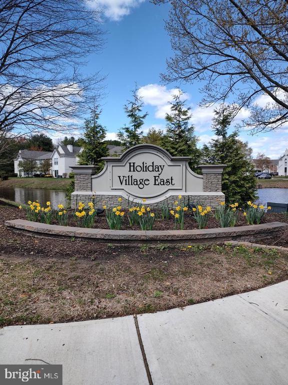 Welcome to 1206B Ginger Court—an inviting, move-in-ready home nestled in the sought-after Holiday Village East community. This beautifully maintained residence offers a perfect blend of comfort, style, and convenience, making it ideal for easy, low-maintenance living.Step inside to discover a bright and welcoming interior featuring updated laminate flooring throughout the main living areas and plush carpeting in the bedrooms for added comfort. The kitchen has been thoughtfully enhanced with new granite countertops, a brand-new electric stove, and a newer garbage disposal—perfect for everyday cooking and entertaining. The adjacent laundry area includes a newer washer and dryer along with custom shelving, providing excellent pantry and storage solutions.Additional upgrades throughout the home include newer light fixtures, a ceiling fan, custom window blinds, and a new storm front door. The spacious bedroom features a walk-in closet, while the bathrooms have been tastefully updated to reflect modern finishes and functionality.Enjoy your morning coffee or unwind in the evening on your private front balcony, where you can take in peaceful, scenic pond views—a perfect backdrop for relaxation.Holiday Village East is a highly desirable 55+ active adult community offering an array of amenities and social activities. Residents enjoy access to pickleball and tennis courts, a community pool, a recently updated clubhouse, and a fully equipped exercise room, along with a vibrant calendar of events.Conveniently located near shopping centers, major highways, and the local library, this home offers both tranquility and accessibility. Experience the lifestyle you’ve been waiting for—living in Holiday Village East truly feels like being on vacation every day.