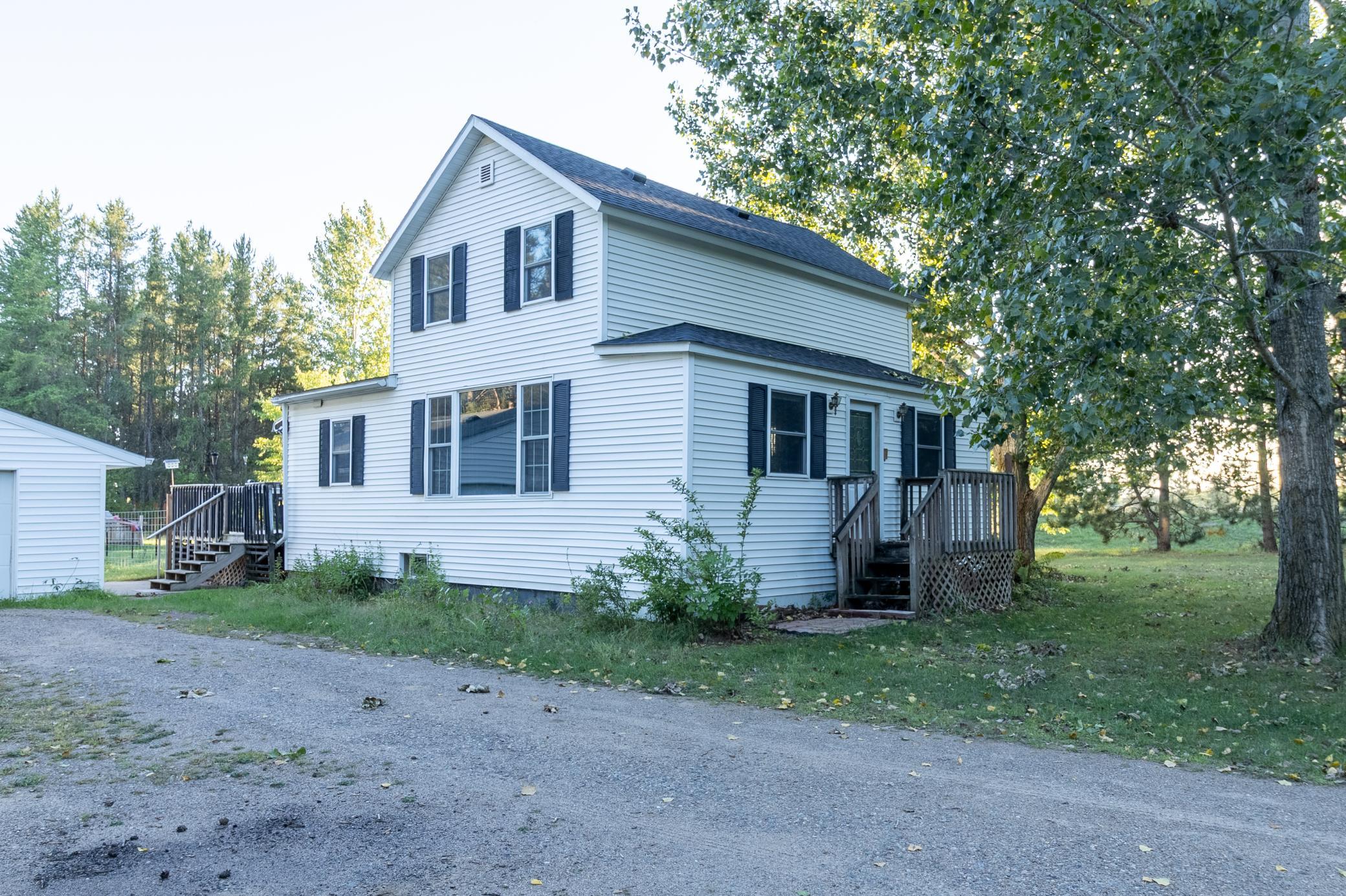 Affordable country-like home on .72 Acre corner lot with rustic modern updates inside such as kitchen with open cabinets & floating shelf, newer appliances, updated bathroom with custom vanity/sink, accent walls in living room and bedrooms, newer flooring & more!  Brand new roof in 2026, large 10' living room window, furnace in 2024, well filter, drain tile & many more extras!  Detached 2 car garage is huge, insulated, heated and fits 4 cars 30x40 total size!  Large deck leading to chicken coop and fenced yard (coop and 15 chickens stay)!  Movie projector in finished basement family room stays!  Don't miss this one!
