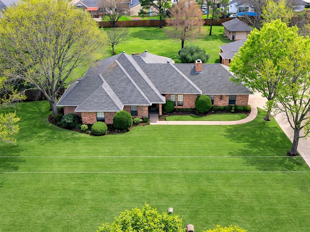 Situated on a beautiful 1-acre lot, this spacious 4-bedroom, 2-bath home offers a great layout, fantastic outdoor living, and a detached 3-car garage along with a separate workshop.Upon entry, you’re welcomed by a spacious living area featuring a brick wood-burning fireplace, custom built-in cabinetry and shelving, and large windows that fill the room with natural light.The kitchen is conveniently located just off the living area and features a large center island with breakfast bar seating, granite countertops, built-in oven and microwave, an electric cooktop, and a spacious dining area with windows overlooking the backyard.Just off the dining area, the oversized laundry room offers excellent cabinet and counter space along with plenty of room for a freezer or second refrigerator.The primary suite features trayed ceilings and a cozy sitting area, along with an ensuite bathroom that includes a large dual-sink vanity, jetted tub, walk-in shower, and split closets.Off the living area is an additional space that adds excellent flexibility and can easily serve as a home office, game room, or flex space that is separate from the other bedrooms.The fourth bedroom, located off the office room, is split from the additional bedrooms and features a large walk in closet.  French doors within the living room lead to the covered back patio, creating a seamless connection to the backyard. The patio overlooks the stunning in-ground pool and oversized backyard, perfect for relaxing or entertaining. The property also includes a separate workshop with electricity and a one-car garage door, ideal for lawn equipment, pool supplies, storage, or hobby use.With 1 acre of space, a pool, a workshop, and a 3-car detached garage, this property offers a rare combination of comfort, functionality, and outdoor living.