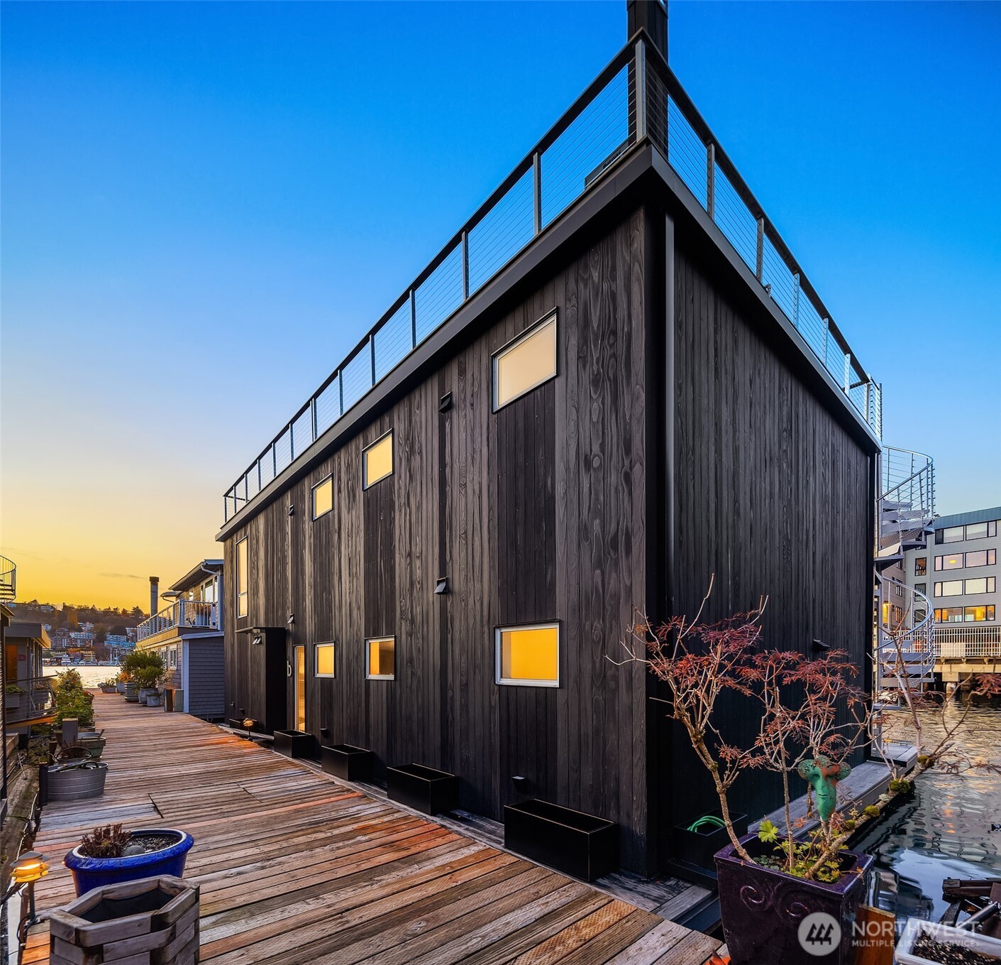 Freshly priced, The Noir House presents an extraordinary opportunity to own one of Lake Union's most thoughtfully designed floating residences. A true turnkey offering, complete with curated furnishings and artwork, simply arrive with a suitcase and begin enjoying waterfront living and the very best of a Pacific Northwest summer. Built Green certified and crafted with uncompromising attention to detail, every space was designed to celebrate life on the water, from the dramatic rooftop entertaining deck to the light-filled interiors and seamless connection to the lake. Every element has been intentionally considered, creating an experience that feels more like a boutique retreat than a residence.  Exceptional craftsmanship is showcased throughout with Fleetwood door systems, striking Shou Sugi Ban cladding, and a thoughtfully curated palette of top-tier finishes. Smart home features including Lutron lighting and integrated Sonos audio elevate everyday living, while an outdoor shower, attached one-car garage, and moorage for a small runabout or skiff complete this exceptional offering. For buyers seeking a lock-and-leave lifestyle without compromise, opportunities like The Noir House are exceptionally rare. Whether as a primary residence or sophisticated urban retreat, this home is ready to be enjoyed from the moment you arrive.