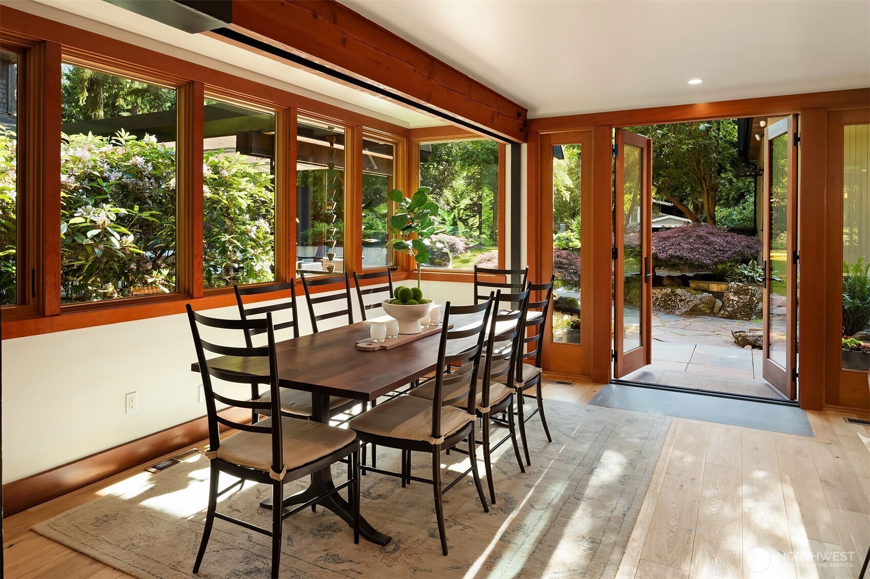 Sunlit dining room with French doors opening to the patio