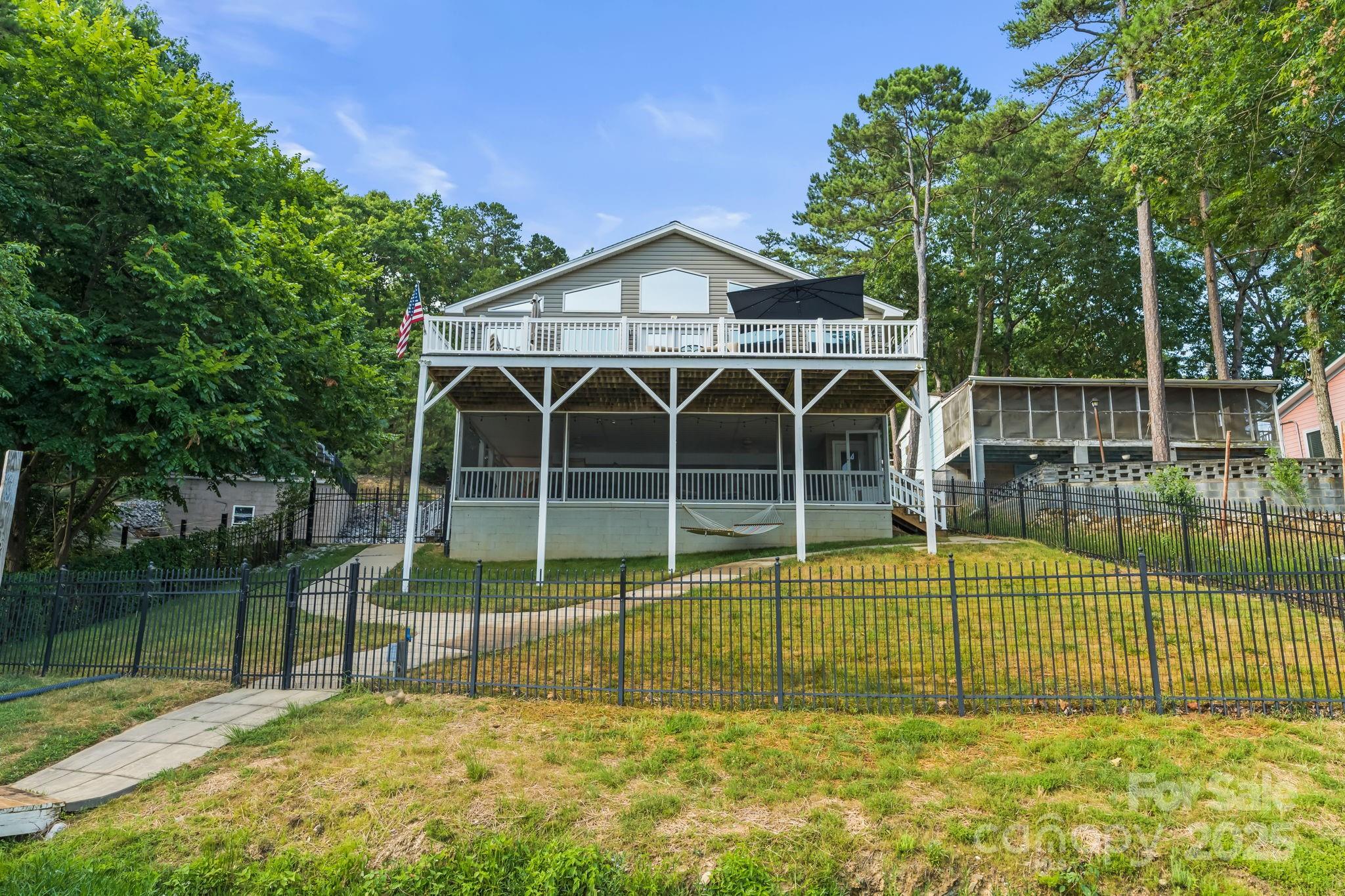 This stunning lakefront property on Badin Lake boasts captivating panoramic views of the water! You'll be mesmerized by the picturesque scenery from the kitchen, dining room, and living room of this single-level, open-floorplan home. Step onto the expansive 32'x16' screened-in porch, perfect for enjoying the outdoors. Feel the tranquility as you relax on the spacious deck. This property also features a boat lift and jet ski dock for all you water adventures. Inside, the primary suite offers a generous walk-in closet and a sizable ensuite. There is a separate storage building and storage space under the house for all your lake toys! Live comfortably by the water with the convenience of a dumbwaiter. Plus, you'll have a stunning view of the Uwharrie National Forest right across the lake. Dixie Shores neighborhood offers a boat ramp for residence.