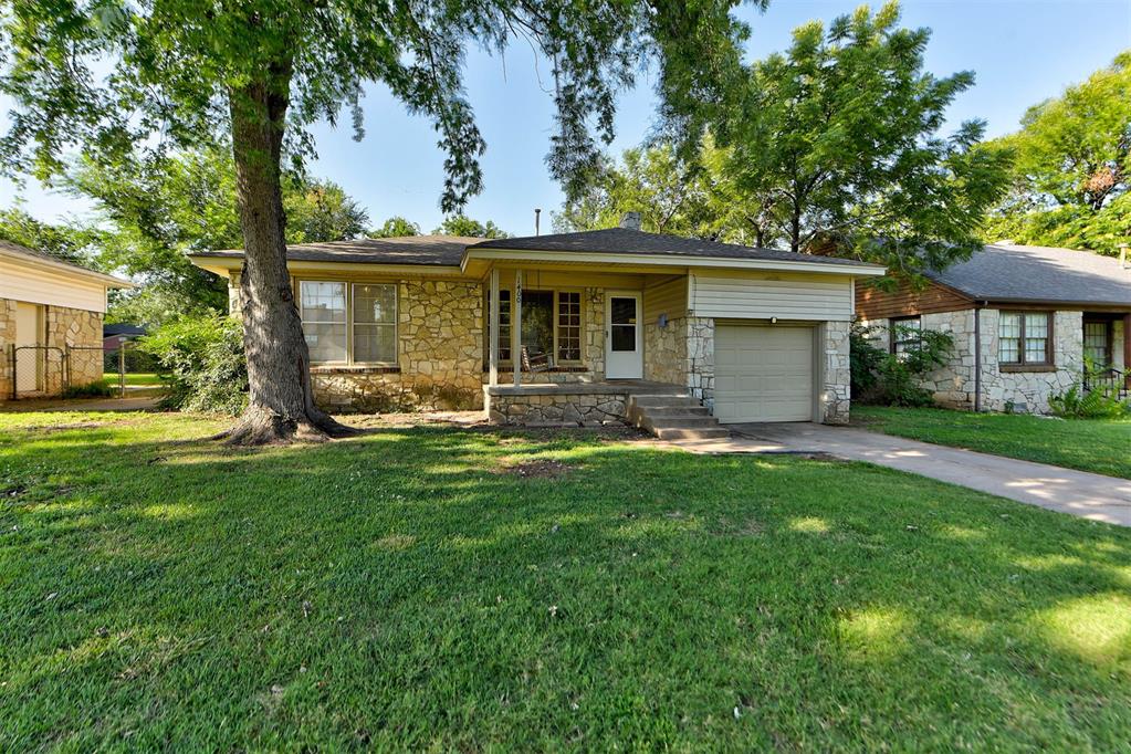 Take a look at this inviting home in The Village! You'll love the oversized covered front porch, complete with a cozy swing—perfect for enjoying a quiet morning or evening breeze. Step inside to a spacious living area featuring charming original knotty wood paneling and a beautiful stone fireplace that adds warmth on chilly nights. The formal dining room flows seamlessly from the living space and easily accommodates a 6-8 person table. The kitchen offers plenty of room to work and dine, with granite countertops, a newer stove, updated wood-look tile, modern lighting, and space for a breakfast nook. Gorgeous refinished hardwood floors in 2024 that run throughout the home, adding character and charm. Both bedrooms are generously sized, each with upgraded ceiling fans and room for queen-sized beds plus furniture. The bathroom has a delightful vintage flair, offering a touch of classic style. Out back, the private yard is ready for play, pets, or relaxing weekends. The garage door has been recently updated too, and let's not forget the location!!! Tucked right in the middle of the city, close to everything. Schedule your private tour today!
