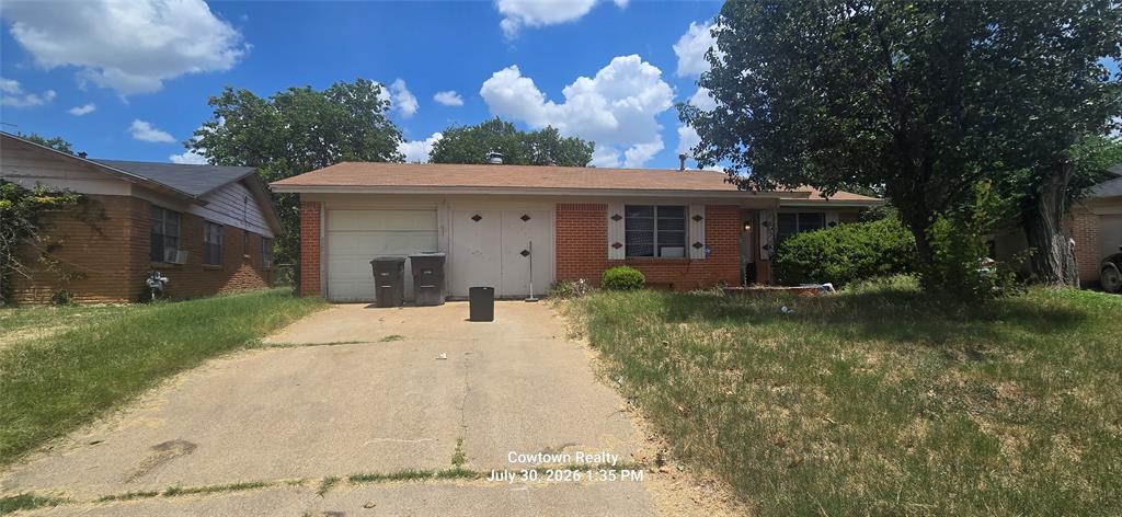Single-story brick residence featuring a concrete driveway and an attached garage