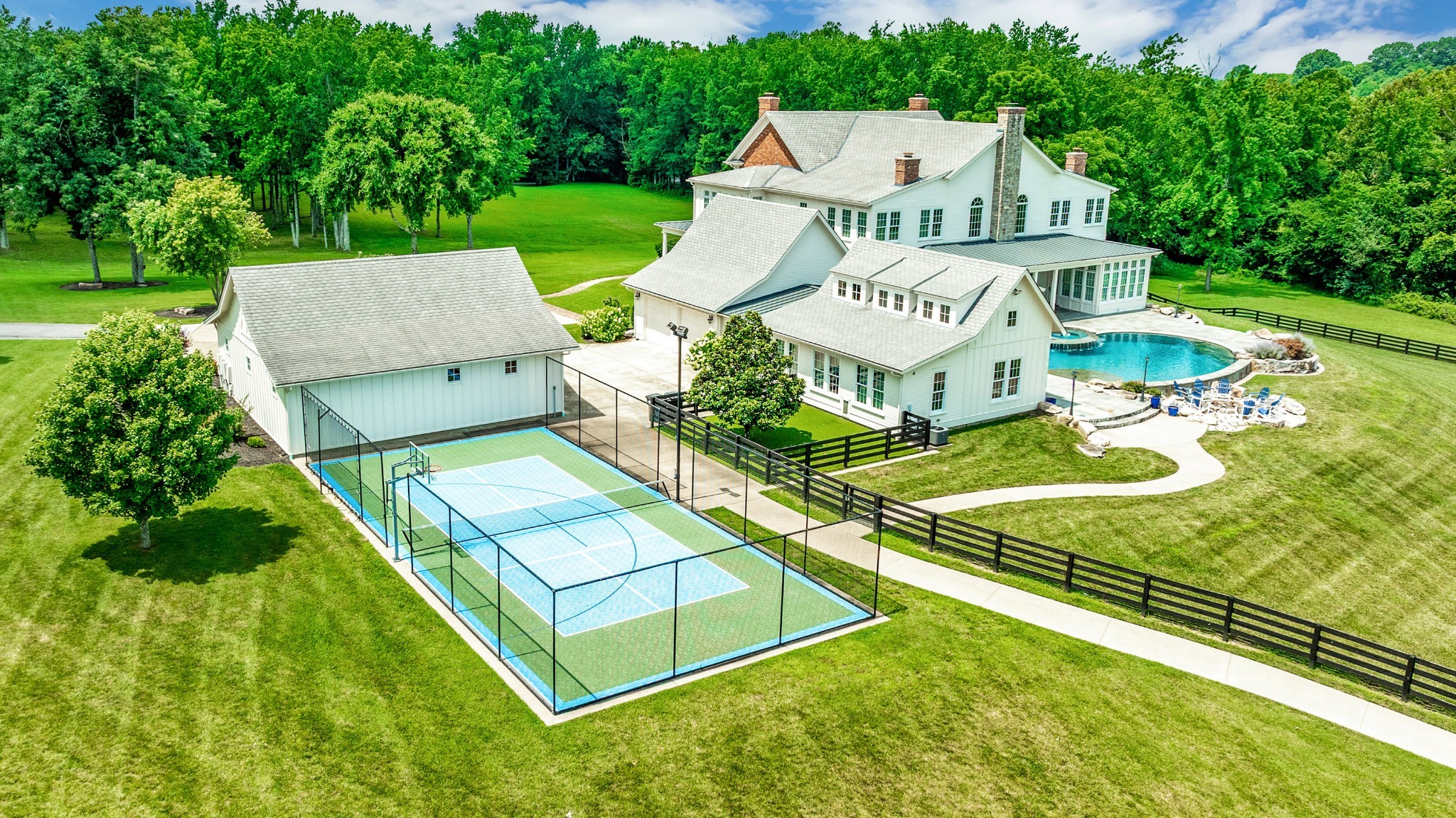 Welcome to the crown jewel of Williamson County — an extraordinary 20-acre luxury estate where timeless Old World craftsmanship meets modern elegance. Privately gated and exquisitely secluded, this majestic 11,000 sq. ft. residence offers the ultimate in refined country living, just minutes from the I-65 corridor.

Inside, soaring 35-foot vaulted ceilings and five custom brick fireplaces set the stage for grand yet inviting living. The chef’s kitchen is a culinary masterpiece, complete with an adjacent prep kitchen and sweeping views from every window. Each of the five spacious bedrooms features its own ensuite bath, with three offering private, climate-controlled sitting porches perfect for reading or quiet reflection.

Elevated amenities abound, including a dramatic two-story great room, a 29' x 28' entertainment/game room with full bath, and an elevator servicing all levels. Wellness is paramount with a professional-grade gymnasium featuring Olympic-level rubber flooring.

Step outdoors to your private resort: a 10 person spa infinity pool with waterfall and sun ledge, lighted pickleball court, and a picturesque lake with fountain and concrete pier — ideal for elegant entertaining. A five-car garage with attached workshop, plus a modern barn with wraparound porch and glass garage doors, complete the estate. Every path from the main home connects seamlessly to the court, barn, lake, and fenced dog run.

The grounds are meticulously maintained with manicured pastures, fresh black plank fencing, and three additional recorded 5-bedroom septic-permitted homesites — offering future development or multigenerational potential.

This 17-room estate also includes an encapsulated, unfinished basement (approx. 1,000 sq. ft.), perfect for storage or future expansion. Whether you're a horse enthusiast, outdoor sportsman, or simply seeking an ultra-private sanctuary, this estate offers a lifestyle unlike any other. 
Additional 15 acre tract available.  Mls #3034465