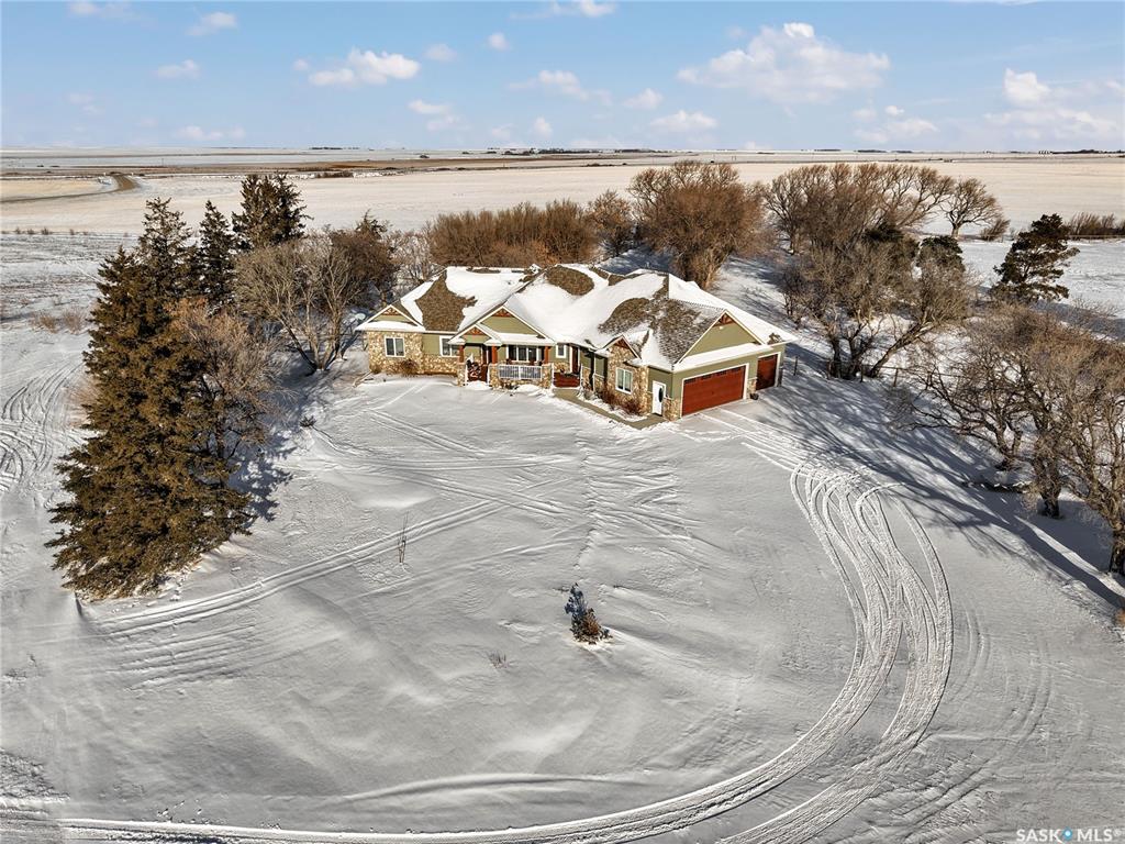 This beautiful, private acreage features 5 bedrooms, 4 bathrooms, a triple-car attached garage, and multiple outbuildings. Located just 22 minutes from Saskatoon, this acreage sits just outside the town of Delisle which features all amenities such as schools, grocery, gas, recreational activities and more. This 2020 built bungalow was customized with high building standards. The veranda at the front of the home provides entry into both the dining room and front hall. The spacious front entry gives access to the triple attached heated and insulated garage, half bathroom and main floor laundry room. The kitchen offers a large island, custom soft closet cabinets and drawers, glass tiled backsplash, quartzite countertops, large pantry and Jenn Air appliances. The kitchen is open to the family room with vaulted ceilings, a propane fireplace and large windows providing both a scenic view and an abundance of natural light. The sun room is fully insulated and can be used year round with a space heater or by leaving the doors open to the main living space. The great room boats 18ft ceilings and a second propane fireplace. Down the hall are three bedrooms including the master suite and the main bathroom. The master offers a walk in closet, five-piece ensuite with a water-air tub, separate stream shower, double sinks and access to the back deck. The outbuildings include the following: Quonset (42 X 70), Shop (20.5 X 33), Horse Stable, 24.5 X 14.5). The workshop is heated and insulated. The large Quonset is finished with a concrete floor and large double doors. The horse stable features two sliding doors and is perfect for horses. The home is finished with 50 year fiberglass shingles, commercial grade ROXUL insulation, triple pane windows, fiberglass doors, high efficient furnace and 100 gallon hot water tank with circulation system. There is a two stage system septic field with pump out and 1500 gallon – fiberglass tank.