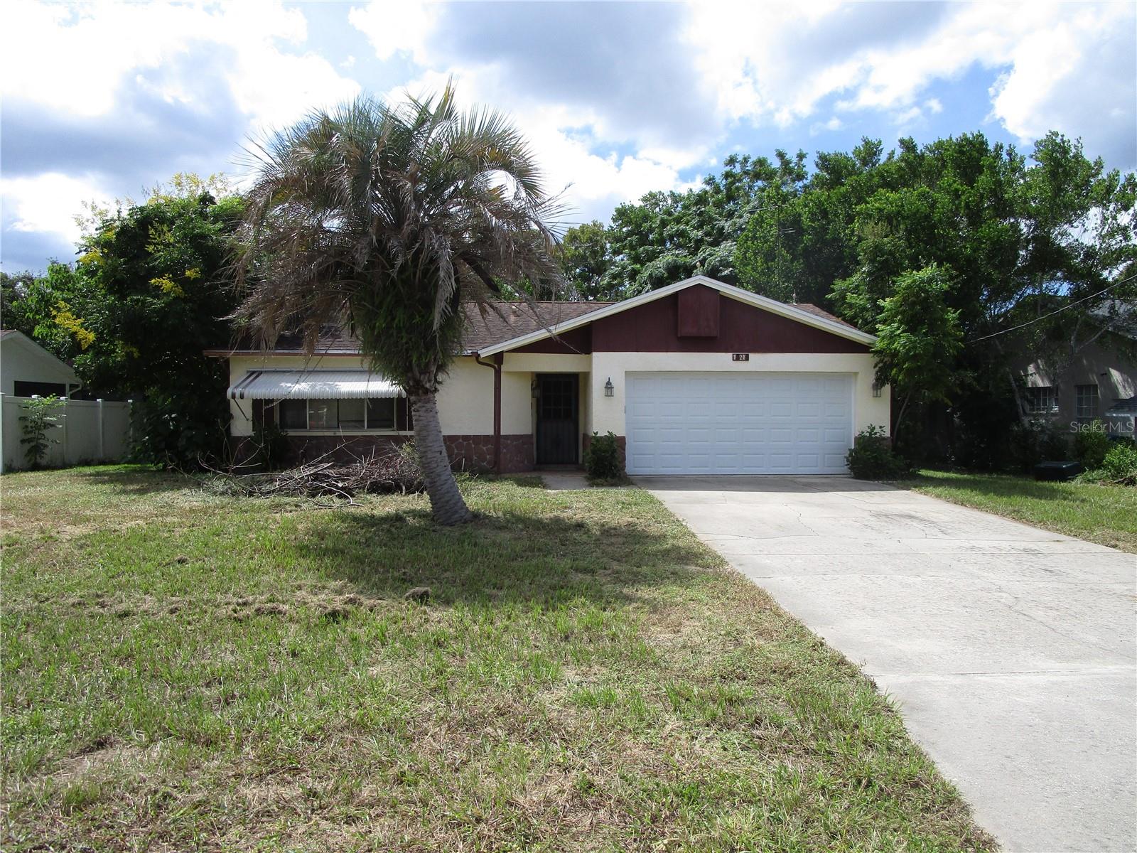 Come check out this home for under 200K, in the heart of Spring Hill! Walk into a large living room with laminate flooring, two big windows, ceiling fan, coat closet. Opens to the dining room with ceramic tile, spacious kitchen, plenty of cabinets, window overlooking the screened porch. Primary bedroom is a generous size with newer/clean carpet, walk in closet,  en suite bathroom features vanity, commode and walk in shower. Hall bathroom features vanity, commode,  tub/shower combo, there is a linen closet in the hallway. Second bedroom has newer clean carpet, fan, closet. Third bedroom was converted from part of the garage, features laminate flooring, closet, ac vent, conversion could easily taken down and made back to the garage. Back patio with crank out windows is large great for morning coffee or evening of relaxing. The yard is huge fenced with a shed. Per the seller Roof is 15 years old, AC was replaced in 1999. ****Being Sold As Is/ conventional or cash This home needs some TLC, cleaning, new appliances, painting. Great location close to restaurants, shopping, hospitals, Weeki Wachee state park close by, Crumps Landing close by, Easy commute to Tampa and Clearwater
