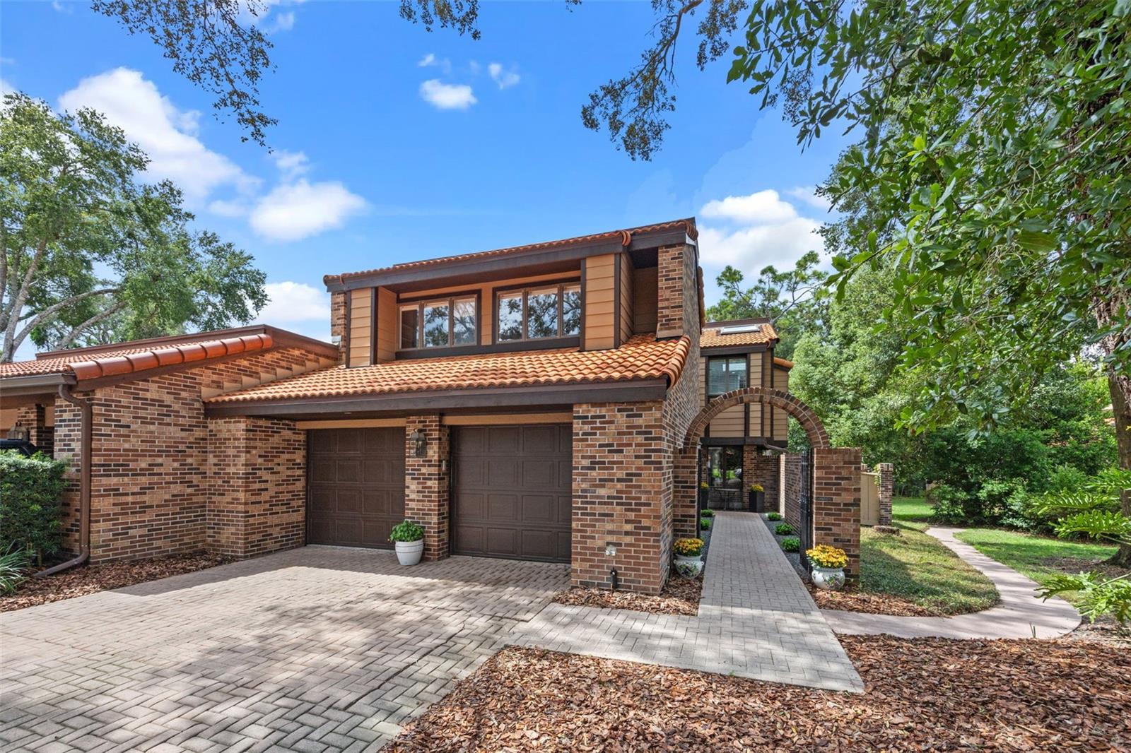 Welcome to this exceptional end-unit residence in The Springs (Whispering Pines) that redefines townhome living. Completely renovated in 2016, this expansive 5-bedroom, 3-bath home offers over 3,750 square feet of thoughtfully designed space—delivering the size, comfort, and privacy of a single-family home with the ease of townhome living.A charming private courtyard with a brick-paver walkway sets the tone as you approach the front entrance of this striking red-brick property. Inside, natural light floods the first floor, highlighting the elegant porcelain tile floors.The kitchen is a true showstopper—designed for both everyday living and entertaining. White soft-close cabinetry, gleaming granite countertops, stainless steel appliances (including double ovens), and a stylish  backsplash make this space as functional as it is beautiful. French doors lead directly from the kitchen to a side patio with access to the large side yard—perfect for grilling and outdoor activities. The kitchen flows seamlessly into the spacious dining room and great room, creating an ideal setting for gatherings and celebrations.Just beyond, French doors open to the Florida Room, an additional light-filled living space overlooking a large two-tier deck—your private retreat for outdoor living. Best of all, open the back gate and you’re just 12 steps away from the Whispering Pines pool and tennis courts. This exclusive enclave includes only 69 residences, offering a truly intimate neighborhood feel.The first floor also includes a convenient guest bedroom and full bath, perfect for visitors or a private home office. Upstairs, the luxurious primary suite features a spa-like bathroom with a walk-in shower designed for two. Three additional generously sized bedrooms and a beautifully updated bath complete the second level.Some recent improvements include a new refrigerator (2025), front door (2025), washer and dryer (2025), and shed (2024).The home is located within The Springs—a private, man-gated community in a top-rated school zone and ideally situated near shopping, dining, and major highways. The Springs is a nature lover’s paradise, where residents enjoy access to a crystal-clear natural spring with sandy beach, miles of scenic nature trails, tennis and basketball courts, swimming pool, fitness center, playground, picnic and barbecue areas, horse stables, and RV/boat storage. The community also hosts vibrant social events, from Friday night food trucks and family movie nights to the annual Philharmonic concert under the stars.Tour today and discover why this is an incredible opportunity not to be missed!