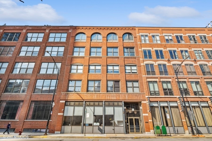 Experience luxury living in this dramatic loft located in the heart of River North. Featuring a 40-foot wall of windows that allows natural light to flood the 14-foot timber ceilings, creating a stunning, open, and airy feel. The loft boasts exposed brick, a split 2-bedroom floor plan, and a large primary bedroom en suite.  Step inside and you'll immediately notice the fully renovated 1800-plus square feet of exquisite urban contemporary design, featuring a highly upgraded modern kitchen with an enormous kitchen island, top-of-the-line cabinetry, and high-end appliances. The bathrooms are exquisitely upgraded, and the unit features upscale lighting, walk-in closets, and plenty of storage space. The ebony oak floors throughout, fireplace, huge windows, in-unit washer and dryer, and other luxurious touches make this loft truly unforgettable. Plus, you'll have one garage parking space included.  The building's re-designed, upgraded lobby, elevators, painted hallways, and carpet are just the beginning. The beautiful landscaped common courtyard garden is the perfect place to relax and unwind. The prime location puts you just steps away from the world-class East Bank Club, the Chicago River, renowned galleries, famed Chicago restaurants, and nightlife. You'll also be close to expressways, parks, and just a short walk to Michigan Avenue and the Lakefront.  Don't miss your chance to live in this one-of-a-kind, stunning loft that combines the best of modern design with historic charm. Schedule your tour today!