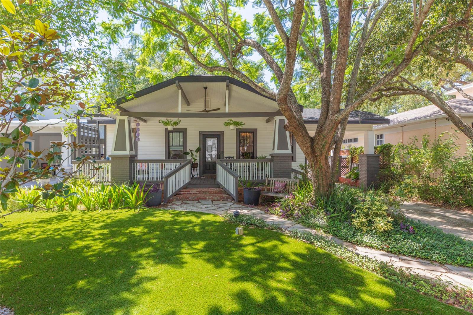 Charming 3 bedroom, 2 bath Craftsman home in premier South Tampa location just minutes from Bayshore Blvd! NO FLOOD ZONE! From the inviting front porch to the welcoming interior, the home maintains its original character while offering updates that complement its timeless appeal. Updates include: Interior paint (2025), tankless water heater (2024) A/C (2024), ROOF (2023), Astroturf front lawn with refreshed landscaping, cleaned/sanitized/re-insulated attic, refinished hardwood floors in the bedrooms, as well as new soffit and fascia. Stepping inside, the two-sided corner gas fireplace adds warmth and ambiance between the formal living room and dining room. The kitchen boasts stainless steel appliances (with gas range and newer refrigerator!), recessed lighting , granite countertops with large center island and nearby wet bar with wine fridge. The primary bedroom has a tastefully remodeled ensuite bath with marble tile. Both secondary bedrooms are ample in size and share the remaining full bath. The updated family room features exposed beams, a wood-slat feature wall, new sconces and LVP flooring, creating a comfortable gathering space with plenty of personality. NEW argon filled aluminum French Doors open to the back patio, designed for seamless indoor-outdoor living and effortless entertaining. The fully fenced backyard is complete with a new covered pergola and a detached workshop/shed for hobbies, storage, or a dedicated workspace. As an added bonus, the carport adds convenient covered parking. Enjoy nearby Hyde Park, Channelside, downtown Tampa, top-rated medical facilities, MacDill Airforce Base, Tampa International Airport and more!