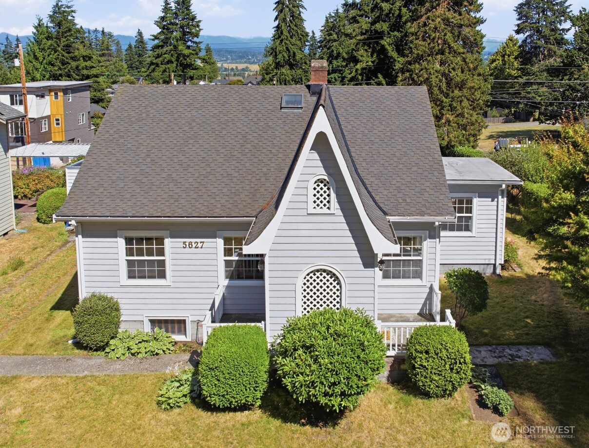 UR4 ZONING! Stunning 1927 Tudor Revival in Everett’s coveted Laurel Heights, blending timeless architectural charm, exceptional craftsmanship & rare development potential. Located on 10,890sf corner lot w/alley access, it offers the opportunity to build up to 2 1,000sf DADUs or a triplex while enjoying or renting the 4 bed/1.5 bath 2,857sf home. Classic Tudor vestibule welcomes you into open LR  featuring coved ceilings, original hardwood floors, wood-wrapped windows & striking fireplace w/period mantel, tile hearth & vintage wall niche. Lrg kitchen offers generous cabinets & counter space, appliances, dining area w/slider to spacious deck & a pantry room w/additional deck access. Main floor includes full bath & 2 generous bedrms including charming Primary w/original crown molding & lrg closet. Upstairs are 2 bedrms w/cathedral ceilings, skylights, built-ins & abundant character. One opens to a rooftop deck w/breathtaking Cascade views & the other is 80% renovated. Partially finished basement offers finished storage rm & exterior access. Detached carport for off-street parking from road or alley. Recent updates: 200-amp electrical panel w/surge protection (2022) & 50-gal water heater (2026). Located by Everett Golf & Country Club. Exceptional property w/perfect blend of historic beauty, modern updates & outstanding development opportunity. If seeking a distinctive residence or investment property, this incredible home offers you the luxury of both. Effective yr built 1970
