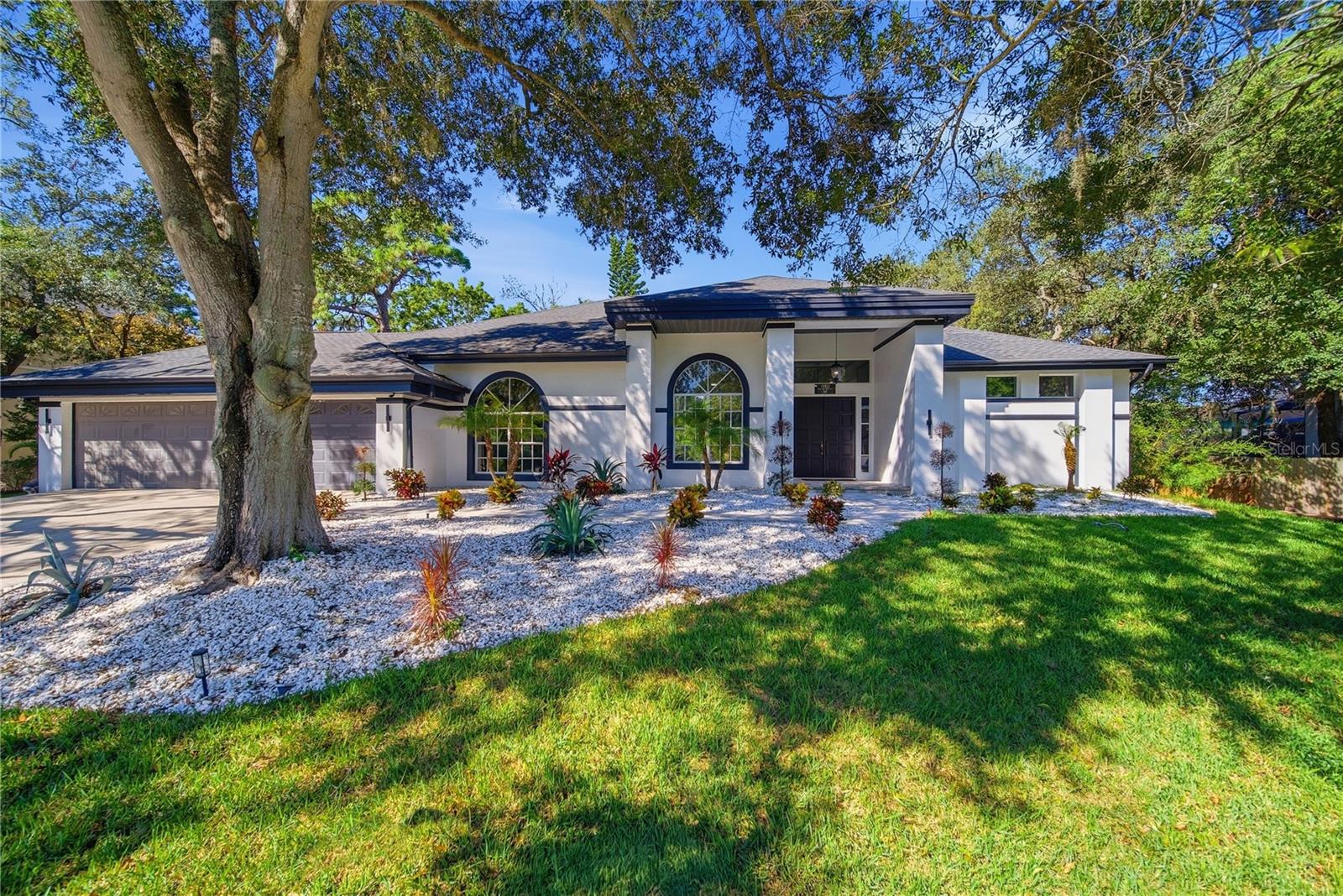 Virtually Staged. This exceptional executive home is nestled within The Bend, one of Tarpon Springs' distinctive custom-home communities offering a blend of privacy, elegance, and refined Florida living.  This home is surrounded by natural beauty, creating a private retreat just minutes from the conveniences and coastal attractions of Tarpon Springs. Extensively transformed in 2026, the residence blends character with sophisticated contemporary finishes.  From the moment you enter, soaring ceilings, abundant natural light, and expansive open living spaces create an inviting atmosphere of understated elegance. At the hear of the home, a stunning chef's kitchen serves as both a beautiful focal point and a thoughtfully designed gathering space, perfectly situated for everyday living and effortless entertaining.