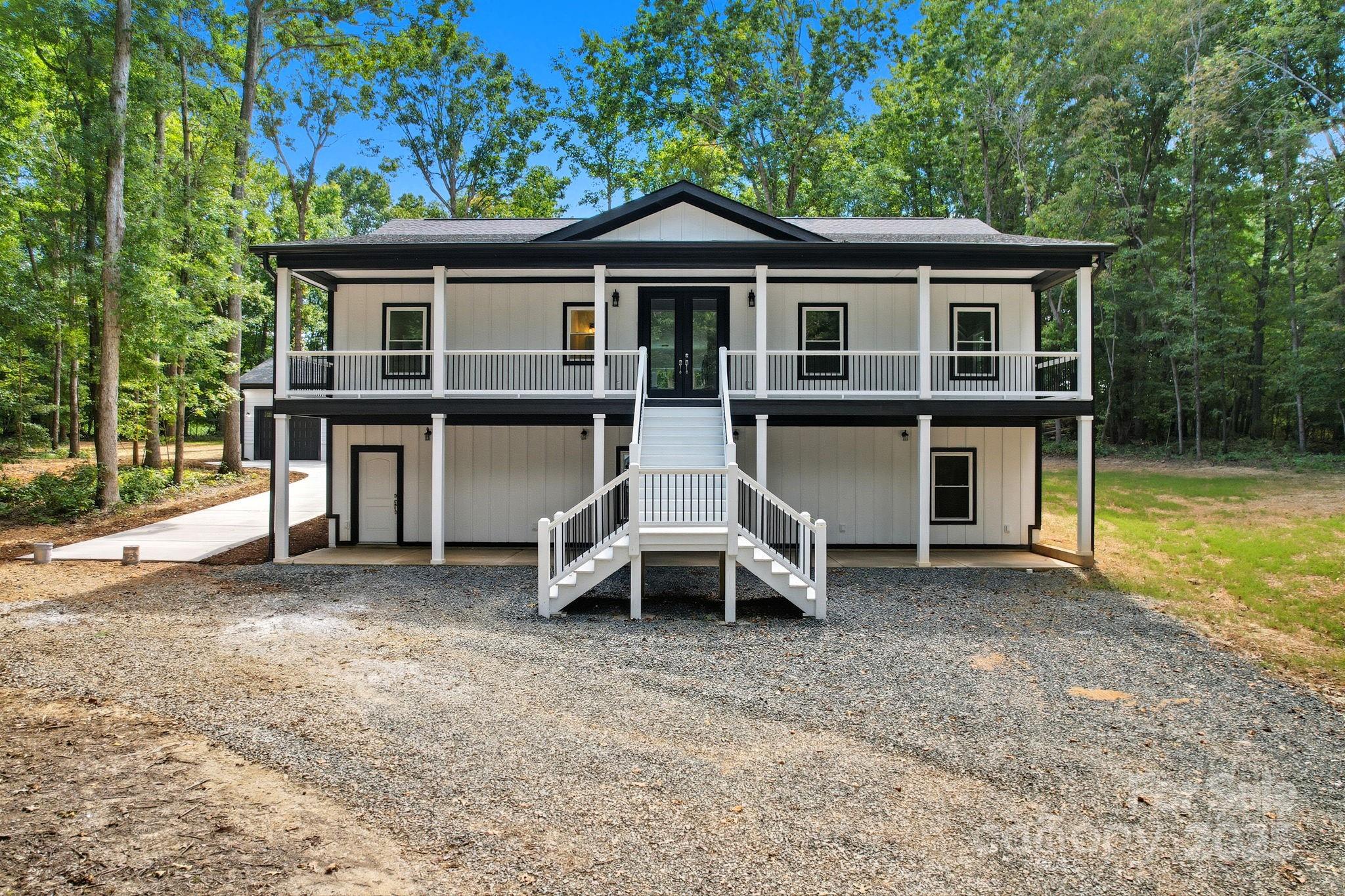 Welcome to a truly remarkable residence offering 4,352 heated square feet of refined living space. Thoughtfully designed with timeless details, this 4-bedroom, 3.5-bathroom estate blends sophistication with comfort.  Arrive in style along the tree-lined driveway, leading to the grand entrance and expansive grounds.  The primary suite on the main level is a retreat of its own, featuring a bricked walk-in shower, oversized tile, a breathtaking picture window, and an expansive walk-in closet. A second primary suite downstairs ensures flexibility for multigenerational living.  The heart of the home is the chef’s kitchen, complete with an oversized quartz island offering built-in storage, custom soft-close cabinetry, tile backsplash, stainless steel appliances, and a convection oven—perfect for both everyday living and entertaining.  Soaring spaces begin in the grand foyer, flowing into a living area anchored by a stunning stone fireplace with slate hearth. On the lower level, the basement living room offers generous space for entertaining, complete with a wet bar for hosting gatherings with ease. Custom decks span the full length of the home, extending your living space outdoors.  Additional highlights include: Private office on main level, free standing soaking tub in primary bathroom, Finished- insulated 3-car garage, Cove crown molding throughout, Two 50-gallon hot water heaters, and Expansive custom decking for entertaining or quiet retreat.  This estate is a showcase of craftsmanship, luxury, and functionality—designed to elevate every aspect of living.