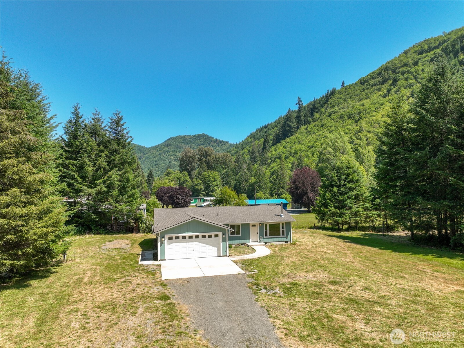 Welcome home to this beautifully maintained 2019-built property offering approximately 1,400 square feet of comfortable, move-in-ready living. Featuring 2 bedrooms, 2 bathrooms, and a versatile office/den, there's flexible space to fit your changing needs—whether you're working from home, pursuing hobbies, or welcoming guests. Mini-splits provide efficient heating and cooling year-round, while the wood stove adds warmth and ambiance on cool evenings. An attached garage offers everyday convenience and extra storage.Set on two parcels totaling more than 2 acres, this level property provides room to enjoy the outdoors with a spacious yard, mature timber, and Rainey Creek access. Garden, play, entertain, or simply relax in your own private setting. A well-cared-for home with space to grow, unwind, and enjoy the best of country living.