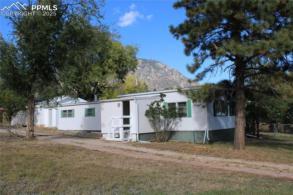 This clean and easy-living maufactured home has all you need for quiet living at the base of Cheyenne Mountain, yet comes complete with a very nice newer 2-car garage and workshop for those who need extra space for their toys.  The back of the property has alley access for the garage and the rest of the property and there is pleny of room on the .46 acres to park your RV, trailer or equipment.  This 3 bed, 2 bath provides a comfortable space and lots of possibilities.  Looking at Cheyenne Mountain every morning and evening is such a wonderful bonus!