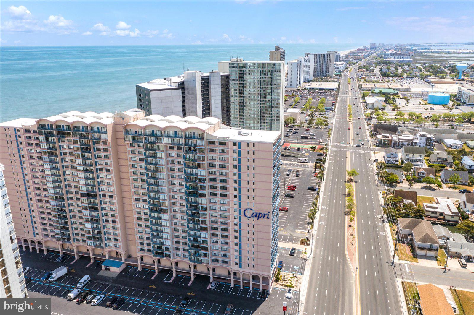 Stunning 5 Bedroom | 3.5 Bath Luxury Condo — Fully Reimagined from the Ground Up.  Step into an extraordinary, one-of-a-kind residence where every inch has been meticulously redesigned with craftsmanship, functionality, and sophistication in mind. This expansive 5-bedroom, 3.5-bath 3200sq ft condominium delivers the space of a single-family home paired with the convenience and elegance of modern coastal living.   The custom entryway sets the tone for the elevated design featuring solid wood herringbone floors and beamed ceiling.  The expansive living room extends the design providing a perfect space for relaxation and entertainment with a custom framed wall for TV, large fireplace, and architectural niches.  A wall of windows and sliders provide access to a massive outdoor deck showcasing stunning views of the Assawoman Bay.  The Chef’s Kitchen was rebuilt to twice its original size as a culinary showpiece and the heart of the home. Features include Fisher & Paykel induction range, refrigerator and freezer columns, and dishwasher, plus touchless faucet and custom aquamarine cabinetry (including panel-front appliances), Arabescato Breccia marble backsplash, and sparkling white quartz island. A butler pantry provides additional space, sink, and wine cooler, perfect for hosting.  The primary suite is a massive retreat with a sitting area and access to your enormous private bayfront balcony.  The room features an entire wall of hidden closets and a fully reimagined bath with marble tile, heated floors, walk-in shower, double sinks, private toilet room, and abundant storage.  The additional guest suites and baths have been transformed with luxury materials and modern conveniences, including all-new tile, tub, fixtures, and lighting and custom closets.  Highlights of the comprehensive renovation include: All new Mechanical Systems: upgraded electrical (fixtures, wiring, and main panel), new plumbing fixtures, and completely redone HVAC ductwork. Premium Finishes include new moldings, baseboards, beamed ceilings, solid cherry interior doors with fluted glass, all-new hardware and solid wood flooring throughout. Comfort enhancements: ceiling fans in every room and whole-home integrated audio system for effortless enjoyment. The Capri Condominiums provide the perfect setting with 24/7 security, 2 assigned covered parking spaces, Olympic size indoor pool, exercise room, tennis, basketball court and library.