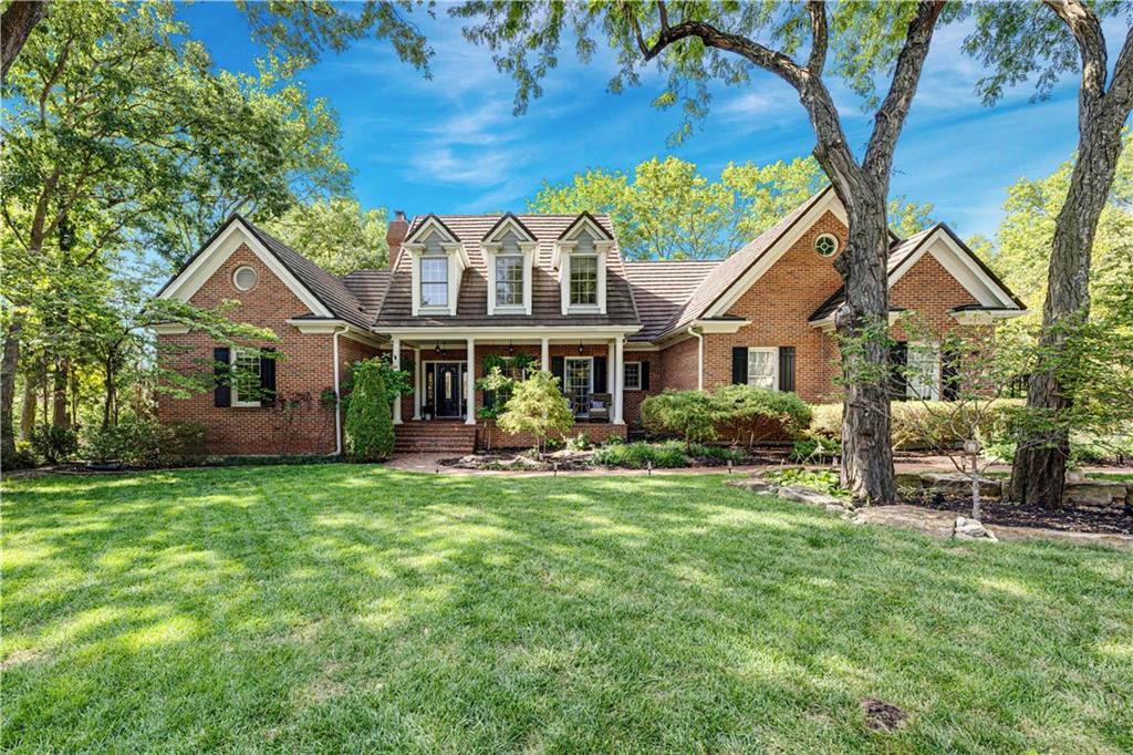 Classic Colonial Charm on a Private, Wooded Half-Acre Lot - Nestled on a private, wooded 0.5+ acre lot within the prestigious, gated Village of Loch Lloyd, this exceptional 1.5-story Colonial residence offers timeless elegance, quality craftsmanship, and spacious living designed for both everyday comfort and effortless entertaining.Step inside to a grand two-story great room featuring a stately fireplace and French doors that open to a spacious composite deck. A formal dining room provides excellent flexibility and can easily serve as a second living area. Designed for both function and style, the updated chef-inspired kitchen boasts a gas cooktop, double ovens, a convenient butler’s pantry, and an adjoining, light-filled breakfast room surrounded by a wall of windows. The main-level primary suite is a true retreat, complete with private deck access, a cozy fireplace, and a fully remodeled bathroom.The fabulous finished lower level features a fifth bedroom (currently utilized as an office), a large family room with a fireplace, a rec room, and a media room complete with a built-in bar—ideal for game nights or movie marathons. All secondary bedrooms throughout the home are generously sized. Entertain or relax on the large deck with views of the lake, or enjoy quiet mornings in the all seasons room with herringbone brick floor.Outdoors, the backyard has been thoughtfully cleared of underbrush to reveal more of the property's natural beauty, creating a usable, scenic outdoor setting with endless potential. Additional highlights include zoned HVAC for comfort and efficiency, and a rare 4-car garage. Enjoy the exceptional lifestyle of Loch Lloyd—a gated community with premier amenities, beautiful surroundings, and a vibrant social scene. Come experience the best of Loch Lloyd living—where every day feels like a vacation.