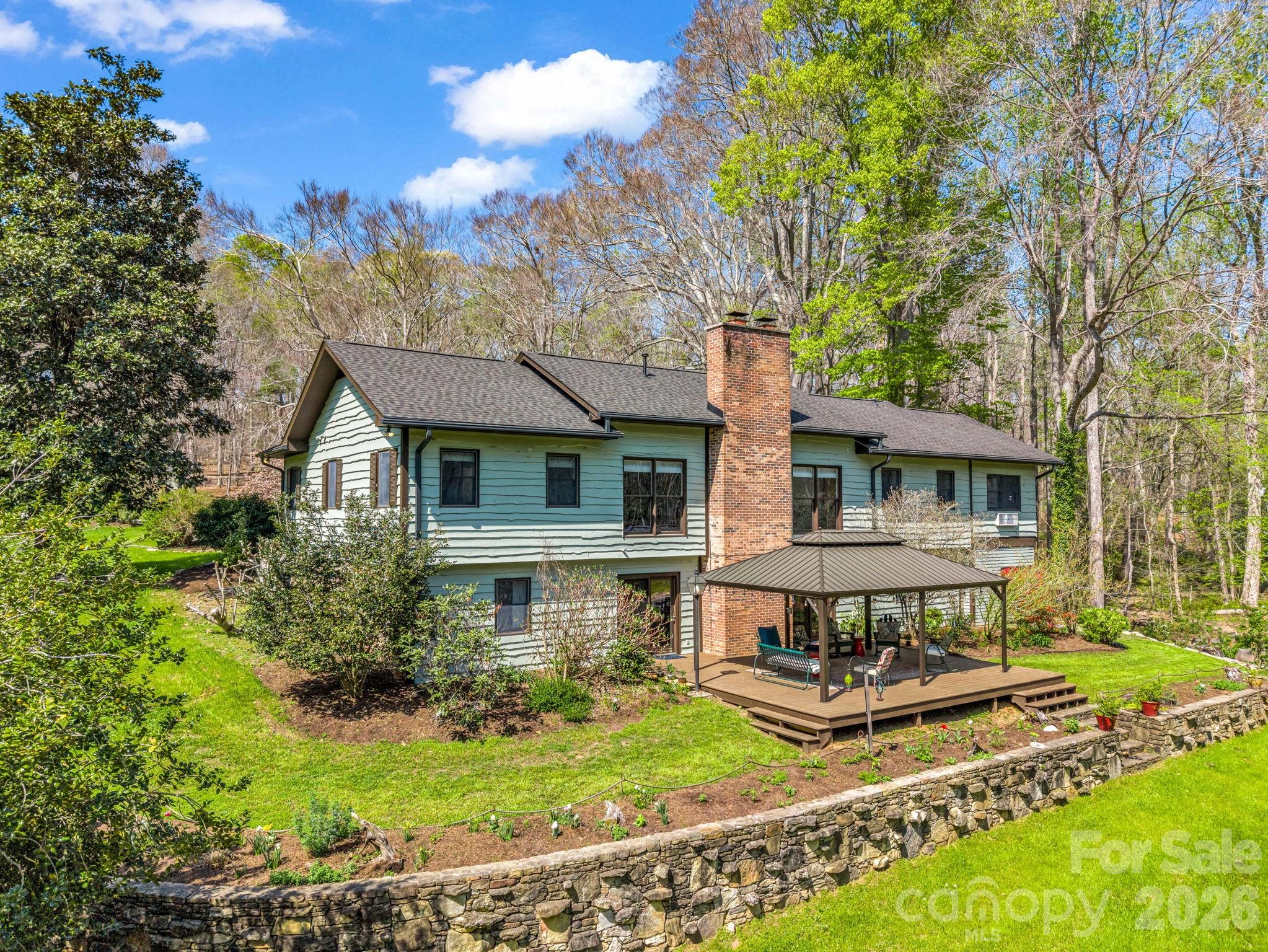 Welcome to Three Creeks Farm, nestled amid the rolling hills of Polk County. This exceptional 27.99-acre estate offers a rare combination of modern luxury, multi-generational flexibility, and equestrian-ready acreage, all set against a backdrop of serene natural beauty and with direct access to the CETA Trail System.Completely renovated in 2019, the 4,182-square-foot main residence blends timeless craftsmanship with contemporary comfort. Inside, open and light-filled living areas feature wood floors, elegant finishes, and beautiful views of gardens, pond, and pasture. The gourmet kitchen showcases high-end appliances, custom cabinetry, abundant counter space, and an inviting flow to the dining and living spaces, perfect for sharing meals or entertaining friends. The primary suite offers spa-quality serenity with a walk-in tub, jet tub, tile shower, and walk-in closet. A second en-suite bedroom downstairs creates an ideal setup for multi-generational living, an in-law suite, or private guest accommodations.Built in 2020, the 988-square-foot guest house adds even greater versatility. With two bedrooms, one bath, and its own full kitchen and laundry, it serves beautifully as a guest retreat, rental opportunity, or home for extended family.The land itself is a showpiece, designed to balance relaxation and productivity. Expansive pastureland, a small two-stall barn, a run-in shed, and direct trail access make it ideal for horses or light agricultural use. A newly constructed workshop with upper-level studio/exercise room and a four-bay equipment building provides space for hobbies, storage, or home-based business needs.Outdoor living is elevated through thoughtful landscaping and harmony with nature: a private pond and waterfall, multiple seating areas to enjoy the surrounding tranquility, and extensive flower, herb, and vegetable gardens complemented by a dedicated pollinator garden. Whether you’re tending to your animals, harvesting from the gardens, or watching deer and songbirds in the distance, every moment here feels rooted in peaceful connection to the land.Additional features include an attached 3-car garage, a gated entry, and no homeowners' association. Just minutes from Columbus and Tryon, this property offers convenient access to shopping, dining, and Polk County Schools, while preserving the privacy and space of country living.Key Highlights:4,182 SF main home (3 bed / 3.5 bath) – fully renovated in 2019,988 SF guest house (2 bed / 1 bath) built in 2020,27.99 acres with pond, gardens, and mature trees,Two-stall barn, run-in shed, pasture, and direct CETA Trail access,Workshop with upper-level studio/home office + four-bay equipment building,Attached 3-car garage, gated drive, and no HOA.Experience the best of Western North Carolina in a private sanctuary designed for livestock, gardeners, and anyone seeking a refined, sustainable lifestyle.1941 Landrum Rd, Columbus, NC,  where style, space, and serenity meet.
