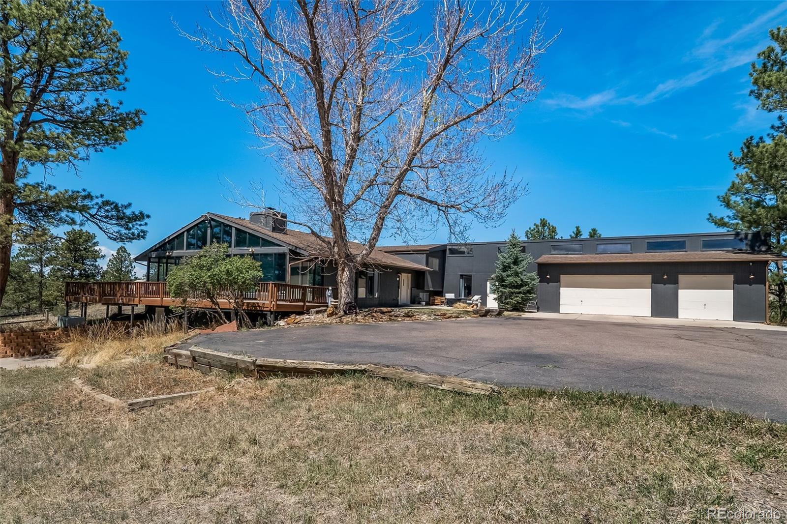 Welcome to your dream retreat in the highly coveted Homestead Hills neighborhood of Parker, CO! This stunning 3-bed, 2-bath home sits on over 5 acres, offering incredible mountain views and a serene wildlife corridor. Enjoy the best of both worlds with quick 5-minute access to town amenities yet a peaceful out-of-town feel. The property boasts over 300 trees, including mature ponderosa pines and a beautiful maple tree. Features include a spacious shop with utilities, chicken coop, 3-car garage, and exclusive bridle path access. The home charms with vaulted ceilings, a large executive suite with separate entrance, sunroom, and a traditional masonry fireplace. The master suite offers a new Juliette balcony and luxury 6-piece bath. Large windows showcase breathtaking views, while modern touches include soft-close kitchen cabinets, wine cooler, and a newly installed Navian tankless boiler. Relax on the wrap-around deck or fenced backyard ready for your pets. A rare find with room for animals and hobbies!
