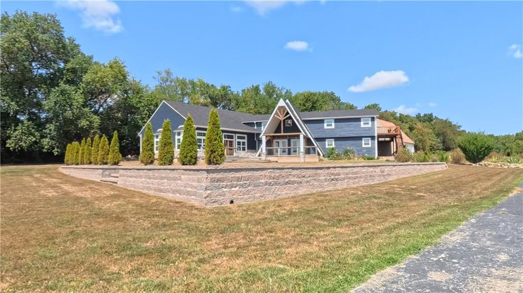 Need room to breathe & enjoy stunning sunsets? This exceptional 9+ acre mini-farm offers space, flexibility, & infrastructure for a self-sufficient lifestyle, hobby farm, small livestock, crop production, or simple country living. Located on blacktop with a paved driveway & beautiful landscaping, this property offers privacy while remaining within approximately 1.5 hours of Joplin, Springfield, & KC.Offering over 5,300 sq.ft. of living space, this spacious home is designed for both everyday living & entertainment. The expansive addition features over 1,500 sq.ft. of open living & dining space with soaring ceilings, wood floors, a beautiful stone-surround electric fireplace, & large windows overlooking the property. A wraparound deck provides additional outdoor living space.The chef-inspired kitchen features custom cabinetry, farmhouse sink, granite countertops, gas range, abundant counter space, & a large walk-in pantry. A built-in bar with lighting, mini fridge, & sink makes the perfect coffee or entertaining station. The main level also offers 5 bedrooms, 2 full baths, an oversized laundry room with utility sink & custom cabinetry, plus a flexible dining or music room. The new main-level bath features a soaking tub & walk-in shower.The partial basement offers plenty of room for a gym, office, theater, rec space, & storage. Upstairs, the private primary suite includes a walk-in closet, en-suite bath with dual shower heads, & private balcony overlooking a pond—perfect for morning coffee & sunrise views. An atrium-style loft & 7th flex room provide additional space for an office, playroom, or retreat.The oversized garage includes a loft with potential for a craft/game room or workshop. Outside, the property includes a barn, shed, & lean-to. The barn needs some work but offers excellent potential for equipment, livestock, or hobbies. Roof & siding replaced with hail storm. A rare opportunity to enjoy acreage, substantial living space & endless possibilities!
