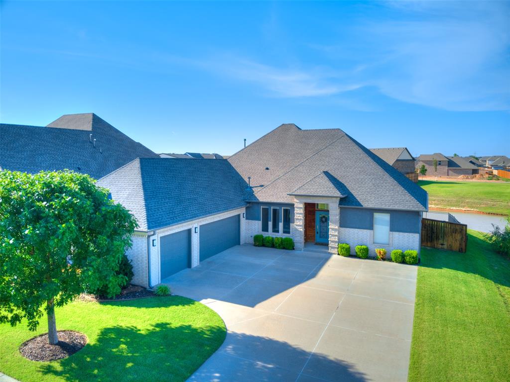 !!! Receive a 1% lender credit toward buyer's closing costs when financing with the seller's preferred lender!!!  Welcome home to this beautifully maintained one-owner modern home situated on a premium corner lot with the neighborhood pond bordering two sides, offering stunning water views from the living room, kitchen, and dining area. Located in the highly desirable gated Windstone neighborhood, residents enjoy access to a clubhouse, pool, basketball court, and playground.  Inside, you'll find an inviting entry, spacious office, and an open living area featuring functional built-ins, a modern fireplace, and large windows that fill the home with natural light. The chef's kitchen is designed to impress with high-end appliances, a massive quartz-topped island, beautiful cabinetry, a built-in pantry with sliding drawers, and an additional walk-in pantry.  The spacious primary suite offers a spa-like bathroom with a soaking tub, shower tower with multiple sprayers, heated towel rack, and a large custom closet with built-ins. Additional features include modern fixtures throughout, a well-appointed laundry room with dual countertops, abundant cabinetry, a built-in mud bench, and a storm shelter in the garage.  This exceptional home combines luxury, functionality, and beautiful views in one of the area's most sought-after communities.