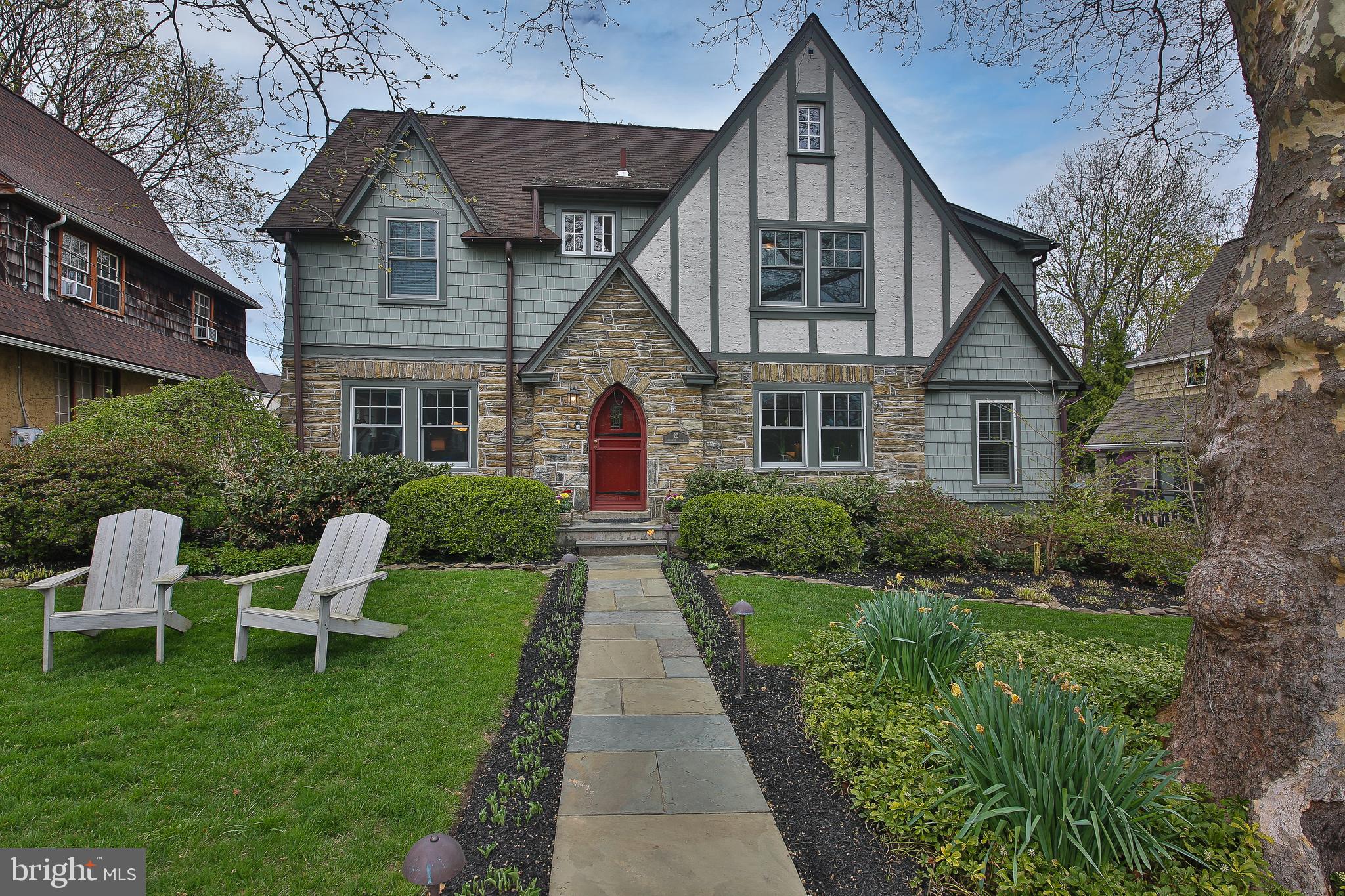 OPEN HOUSE CANCELLED ON 4/18. Walk to Wayne & the train! Welcome to this beautifully renovated stone and cedar Tudor home, blending timeless character with modern comfort in the highly sought-after Deepdale neighborhood.A charming flagstone walkway leads to the original front entry, opening into a warm center hall foyer, from which you will see the inlaid hardwood floors and impressive millwork. The formal living room features custom built-ins, a gas fireplace with a stone surround and detailed mantle, and access to a bright sunroom highlighted by an exposed stone wall. The formal dining room sits across the foyer.The gourmet kitchen features white cabinetry, granite countertops, a farmhouse sink, subway tile backsplash, and a center island with seating. It flows to a cozy breakfast area with vaulted ceilings, skylights, and a large window overlooking the lush rear yard. The spacious family room offers a vaulted ceiling, gas fireplace, heated travertine flooring, and French doors leading to the expansive composite deck—perfect for gatherings and seamless indoor-outdoor living. A convenient powder room completes this level.The current owners thoughtfully reconfigured and updated the 2nd level to create a primary bedroom with custom built-in closets and a luxurious ensuite bath. The bath features a natural wood dual-sink vanity, walk-in shower with bench, clawfoot soaking tub and herring bone tiled, radiant-heated floors. There are two additional sun-filled bedrooms that share a newly-installed Jack-n-Jill bath, which also has radiant floors and a separate water closet. The third floor provides two more bedrooms;  the one that sits behind the “secret bookshelf” has built-in storage, and the other has a private ensuite bath with tiled shower.Outside, the deck overlooks landscaped grounds with accent lighting, fencing, a custom-built treehouse, a garden shed, and a stacked stone retaining wall. The detached 2-car garage provides easy parking and storage.Extensive updates include a renovated 2nd floor, full exterior wood repair and painting, complete interior painting, newer central air conditioning unit and hot water heater, added recessed lighting, and newer windows. Radiant heated tile floors enhance comfort in the family room and full bathrooms.Walkable to Wayne, this home offers easy access to the Strafford train station, shopping, dining, and major commuter routes, with convenient travel to Center City Philadelphia. Pack your bags and enjoy Main Line luxury at its finest!