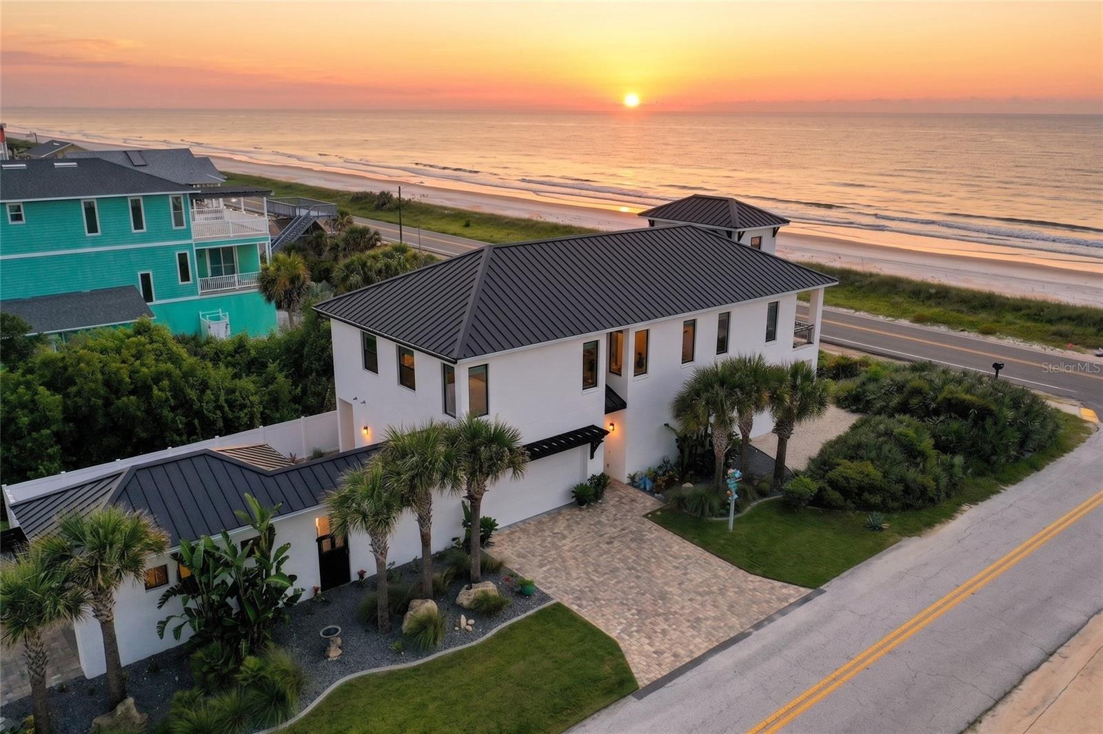 Flagler Beach Custom Coastal Luxury with Panoramic Ocean Views and Beach Access. Experience coastal living at this nearly new custom-built home on South Ocean Shore Boulevard, where sweeping Atlantic views, thoughtful craftsmanship, and everyday luxury come together in one exceptional Flagler Beach address. Built in 2023 by acclaimed Florida builders Intracoastal Construction, this home offers 3,485 square feet of beautifully designed living space, complete with an elevator, 4 bedrooms, 3 full baths, 2 half-baths, beach walkover access directly across the street, and valuable littoral rights. Inside, an open and elevated floor plan captures the best of the beachside lifestyle. The main living area is framed by a wall of sliders leading to a house-width second-floor balcony, creating a seamless indoor-outdoor connection for sunrise coffee, ocean breezes, and effortless entertaining. Eleven-foot beamed ceilings, extensive built-ins, and automated window blinds add warmth, sophistication, and convenience. The chef’s kitchen is designed to impress, featuring granite countertops, a generous granite center island, floor-to-ceiling cabinetry with glass display accents, high-end Italian Fulgor appliances, a professional gas range with pot filler, and a convenient coffee bar tucked into the pantry. The primary suite is conveniently located on the second floor offering large southern windows and ocean views, 11-foot beamed ceilings, automated window blinds. Inside the primary bathroom you have a expansive dual vanity with floor-to-ceiling cabinets, custom tile flooring, a large custom-built walk-in closet with dressers, and a spacious shower with dual shower heads. Outdoor living is equally impressive, with a summer kitchen in the courtyard, an outside bathroom and outdoor shower, extensive manicured landscaping, sprinkler and drip irrigation, a 2-car garage, and a driveway designed to accommodate a 40-foot motorhome or boat with full RV hookups and 50-amp service. A separate 300-square-foot heated and cooled home gym building adds flexible space for wellness, hobbies, or private studio use. Every detail has been thoughtfully considered for comfort, durability, and the coastal lifestyle buyers dream about. From sunrise views over the Atlantic to relaxed evenings in the courtyard, this Flagler Beach residence offers a rare blend of luxury, function, and location. Schedule your private showing today and discover custom coastal living at its finest at 2574 South Ocean Shore Boulevard, Flagler Beach.