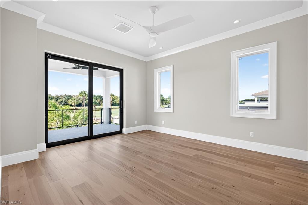 Spare room featuring ceiling fan, light wood-type flooring, and ornamental molding