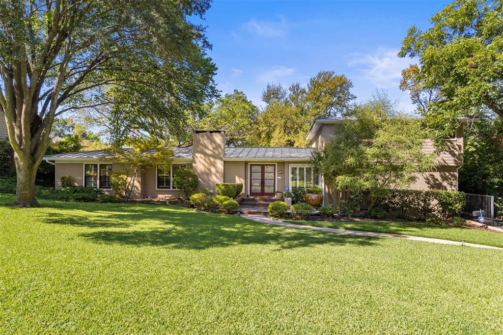 Welcome home to this beautifully updated and immaculately maintained home in coveted Lake Park Estates. This 1950's ranch home has been lovingly restored with attention to detail and quality craftsmanship, including a stunning upstairs primary bedroom addition.  Upon entering 1099 Waterford Drive you are greeted with warm oak hardwood floors and a wall of windows overlooking the lush backyard. The living room, dining room and open floorplan provides the perfect setting for today's functional living while creating a sophisticated and comfortable environment. Updated kitchen with natural soap stone countertops, custom cabinetry and stainless appliances including an induction range. Primary bedroom suite is like living in a tree house with a private balcony perfect for morning coffee. Spa like primary bath features walk in shower, separate soaking tub and dual sinks. Other updates include standing seam metal roof, plantation shutters, all windows and doors and much more. Backyard oasis with a flagstone patio, deck and separate arbor covered patio provides the perfect setting for outdoor entertaining. Oversized carport with a large storage room. Short walk or bike ride to White Rock Lake, Casa Linda Plaza, Dallas Arboretum, local trendy restaurants and coffee shops. Exemplary Hexter Elementary.
