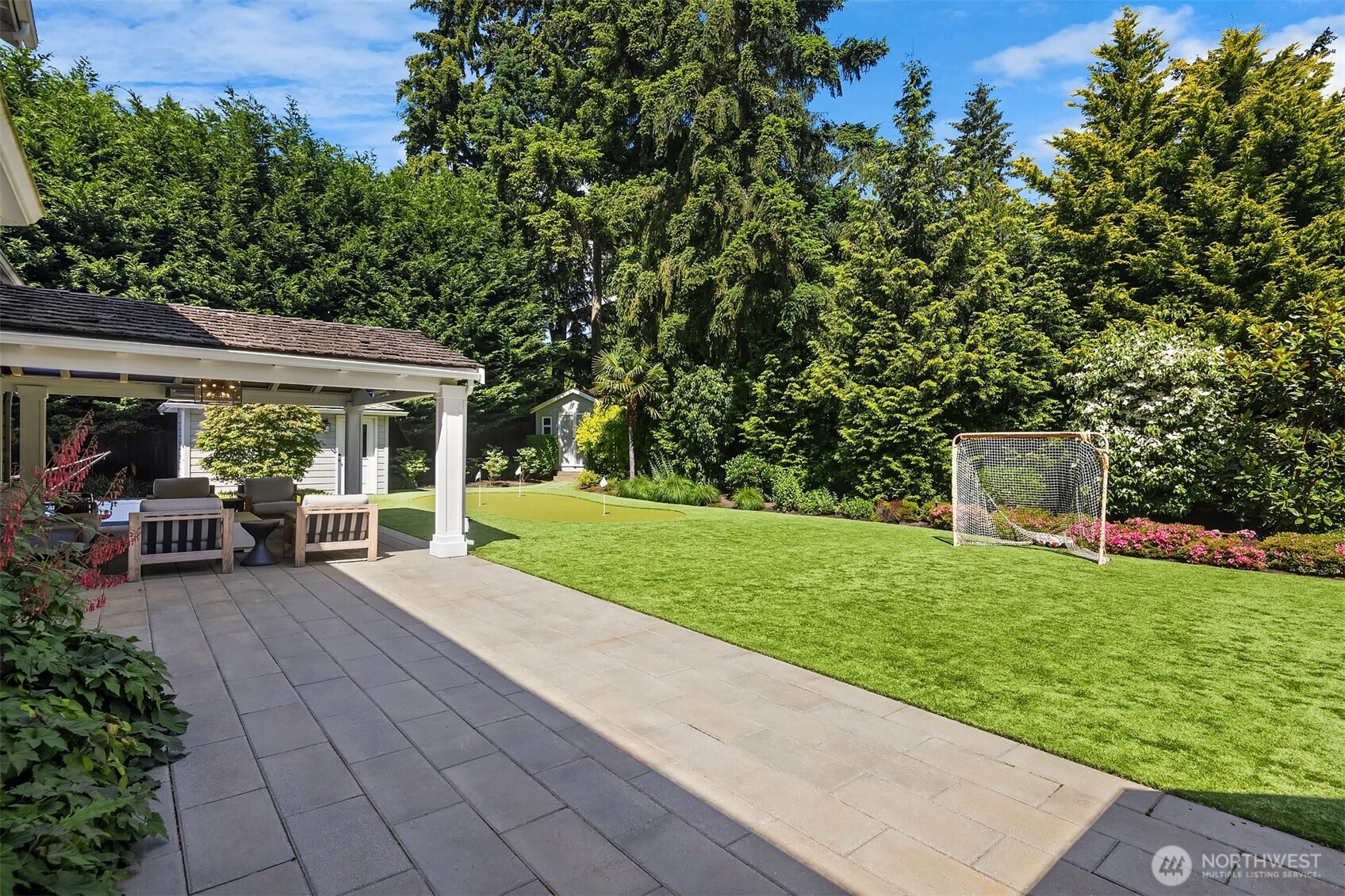 Paver path leading to the manicured backyard
